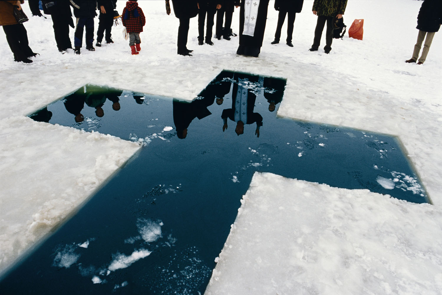MOLDOVA. Transdniester. 2004. The population of Transdniester is mainly ethnic Russians, and the main religion is Russian Orthodox Christianity. Here a priest gives his blessings before a christening in the icy waters of January.