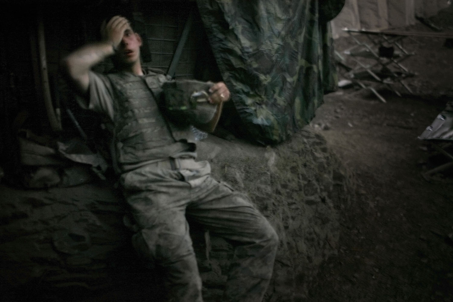 AFGHANISTAN. Korengal Valley. 2007. A soldier from 2nd platoon rests at the end of a day of heavy fighting at the 'Restrepo' outpost. The position was named after the medic Juan Restrepo from 2nd Platoon who was killed by insurgents in July 2007.