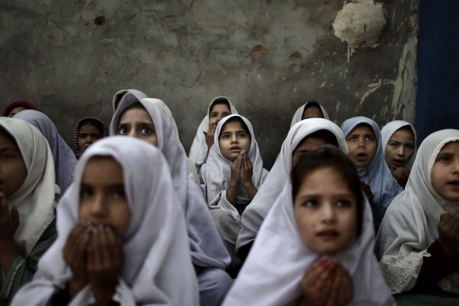 Jan. 3, 2013. Pakistani schoolgirls, who were displaced with their families from Pakistan's tribal areas due to fighting between militants and the army, chant prayers during a class to pay tribute for five female teachers and two aid workers who were killed by gunmen in Northwest Pakistan.