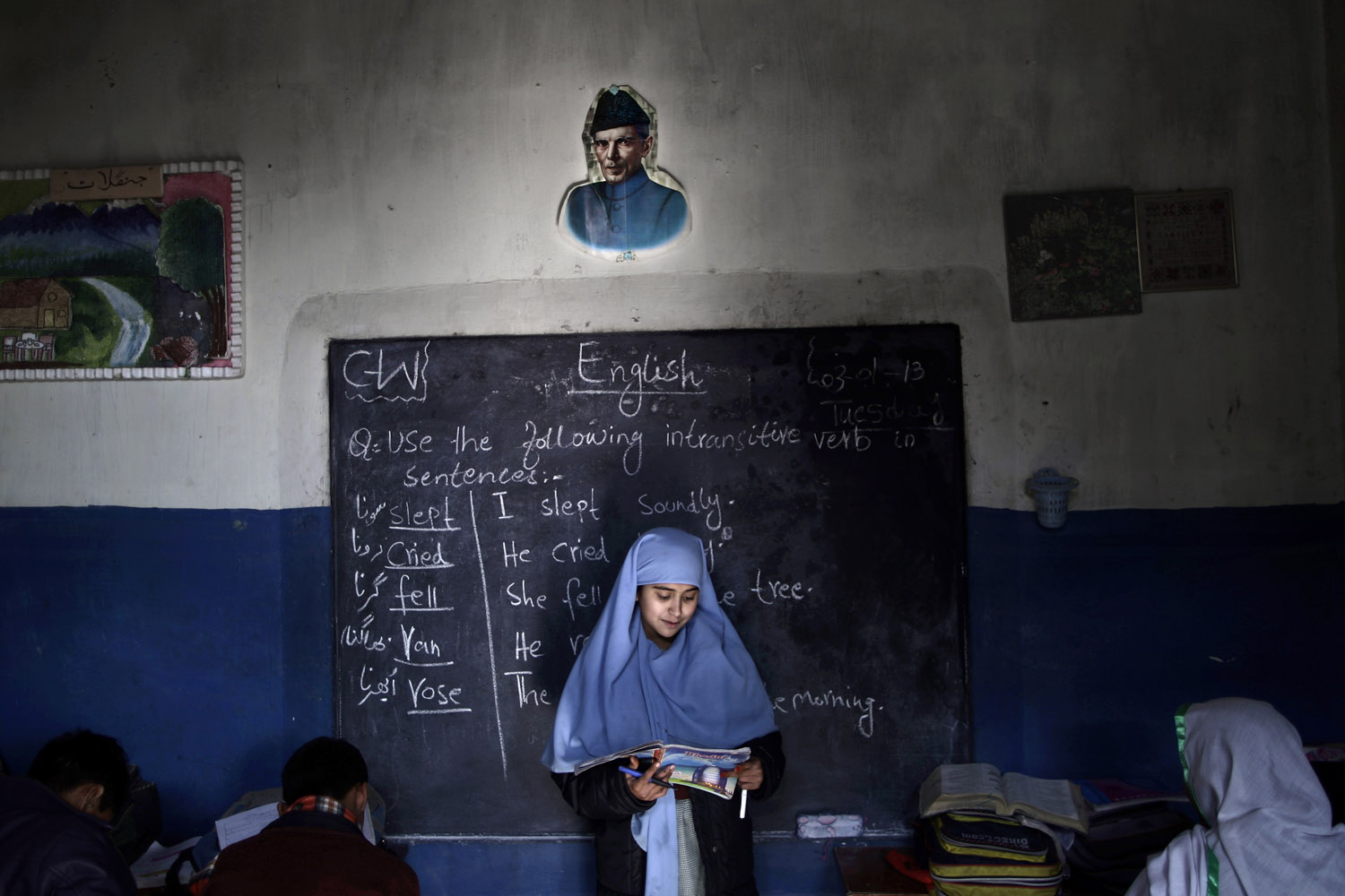 Jan. 3, 2013. Pakistani schoolgirl, Sadia Mukhteya, 12, who was displaced with her family from Pakistan's tribal areas due to fighting between militants and the army, reads in front of the class during an English language class at a school on the outskirts of Islamabad.