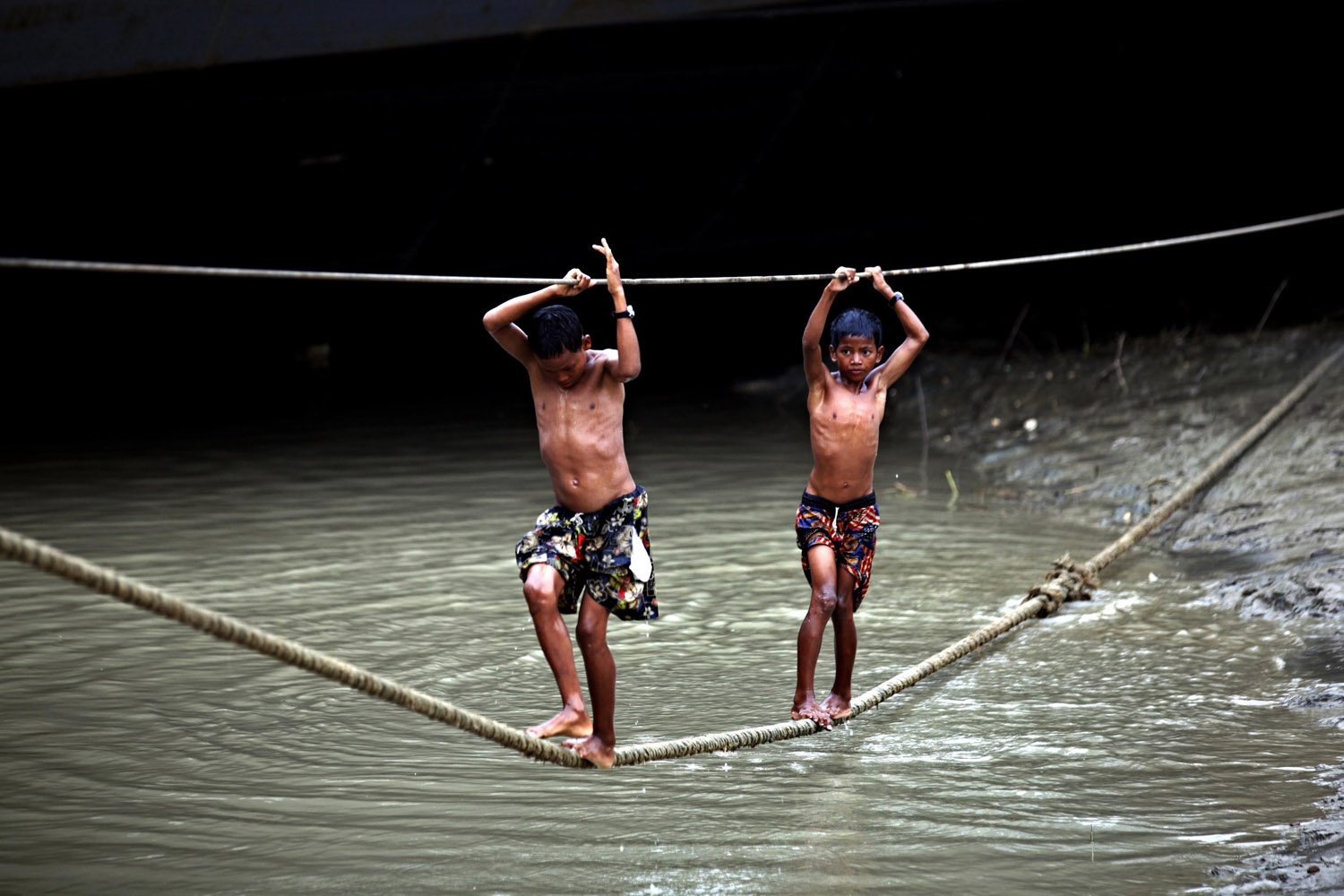 Nov. 25, 2013. Boys play on docking ropes near a dockyard on Hlaing river in Yangon, Myanmar.
