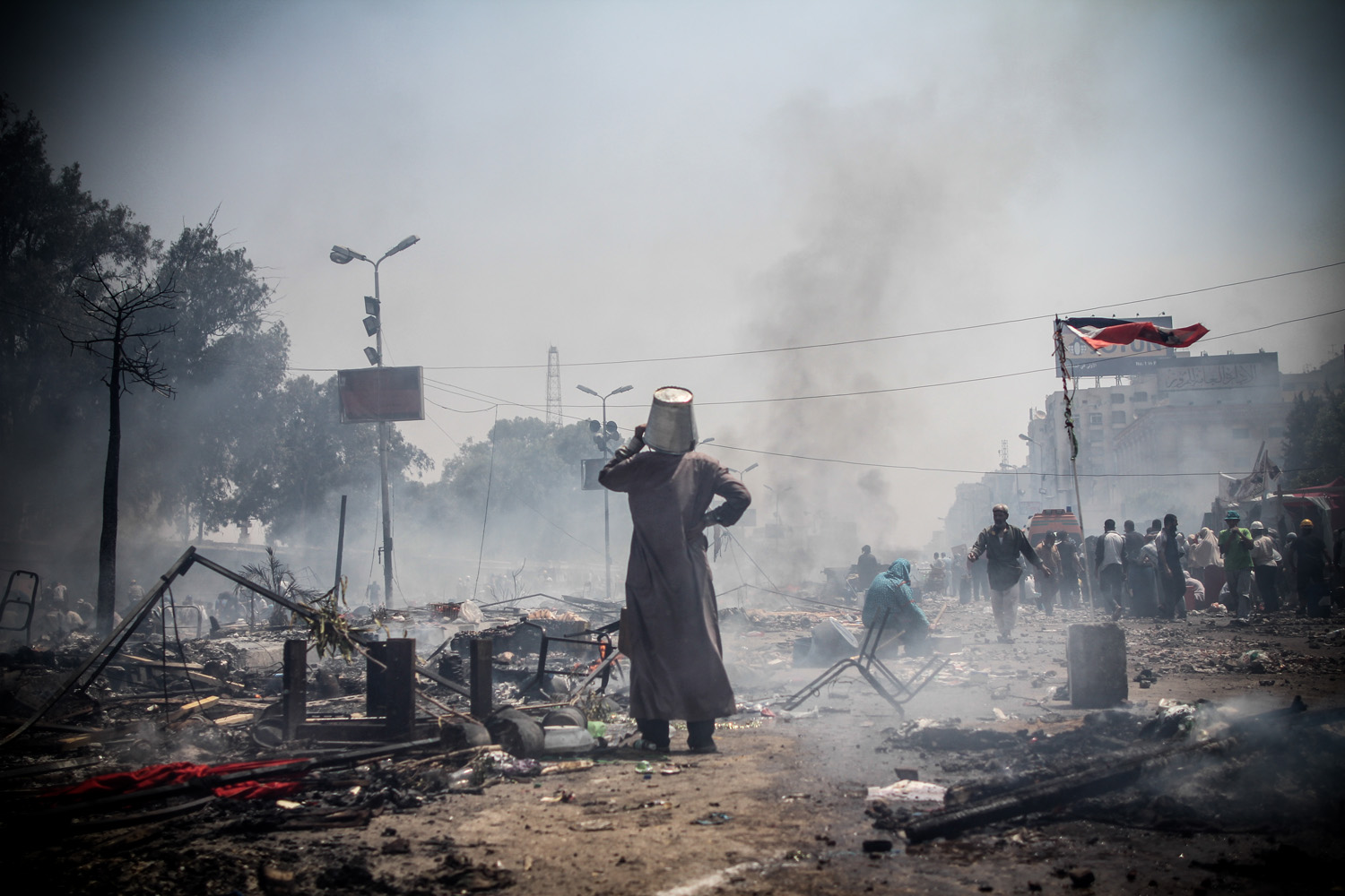 Aug. 14, 2013. A man covering his head with a bucket observes the destruction at Rabaa Adaweya camp during the violent dispersal by security forces.