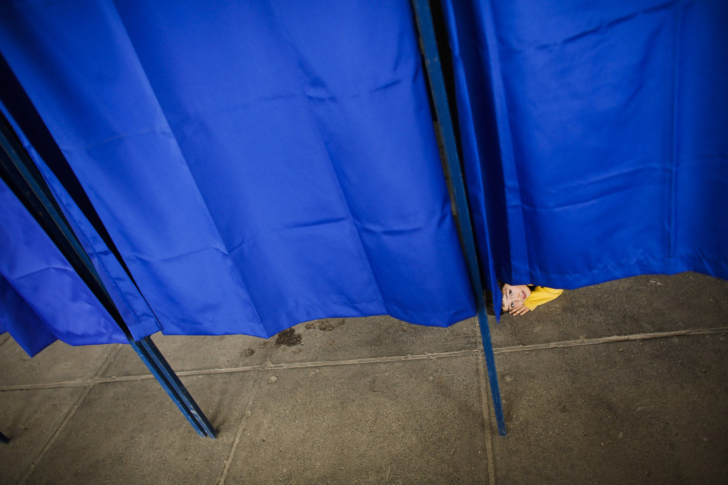 Nov. 17, 2013. A child looks from underneath a voting booth during Chile's general elections at a polling station at the National Stadium in Santiago, Chile.