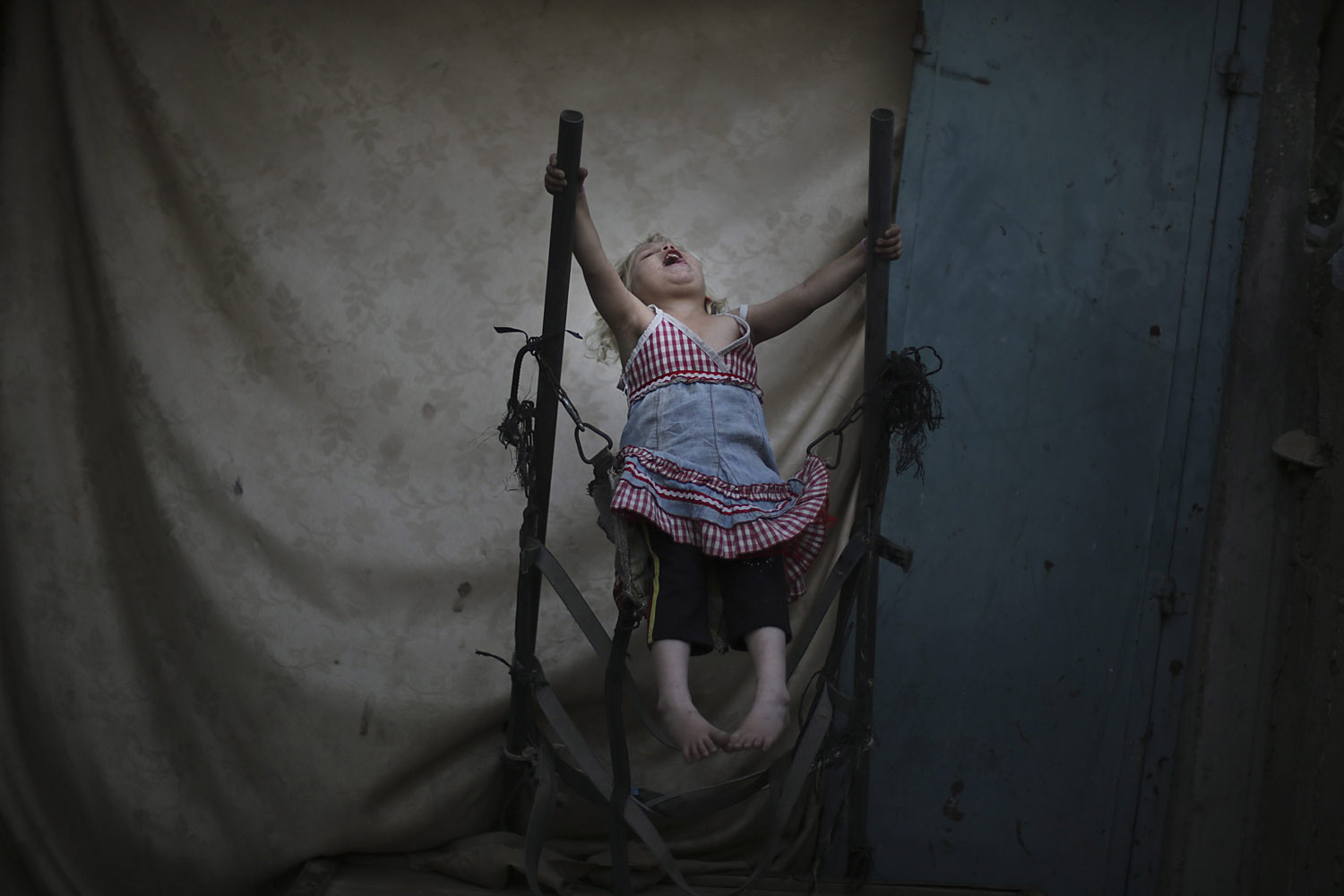 June 5, 2013. A Palestinian refugee girl plays inside her family home in Jabaliya refugee camp, northern Gaza Strip.