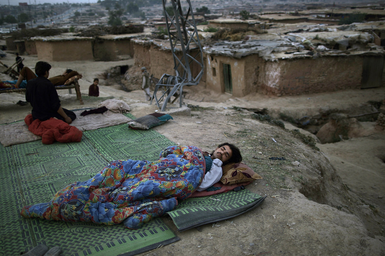 May 20, 2013. A Pakistani man, who fled his home with his family from Pakistan's tribal region of Mohmand Agency, due to fighting between the Taliban and the army, sleeps on the ground on a roadside, on the outskirts of Islamabad.