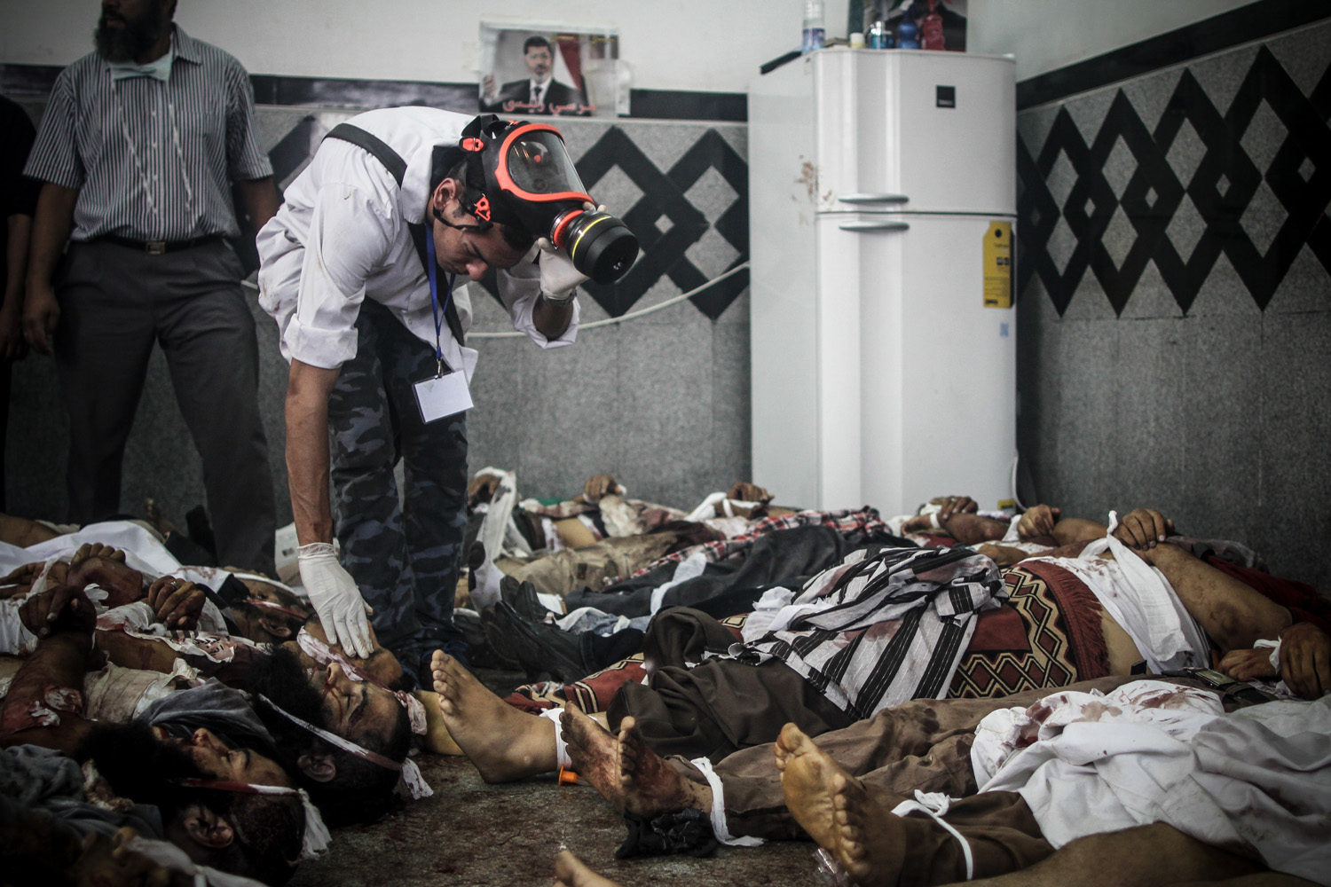 Aug. 14, 2013. A doctor inspects bodies of Morsi supporters laid at a makeshift morgue in Rabaa Adaweya square during the violent dispersal of the camp by security forces.