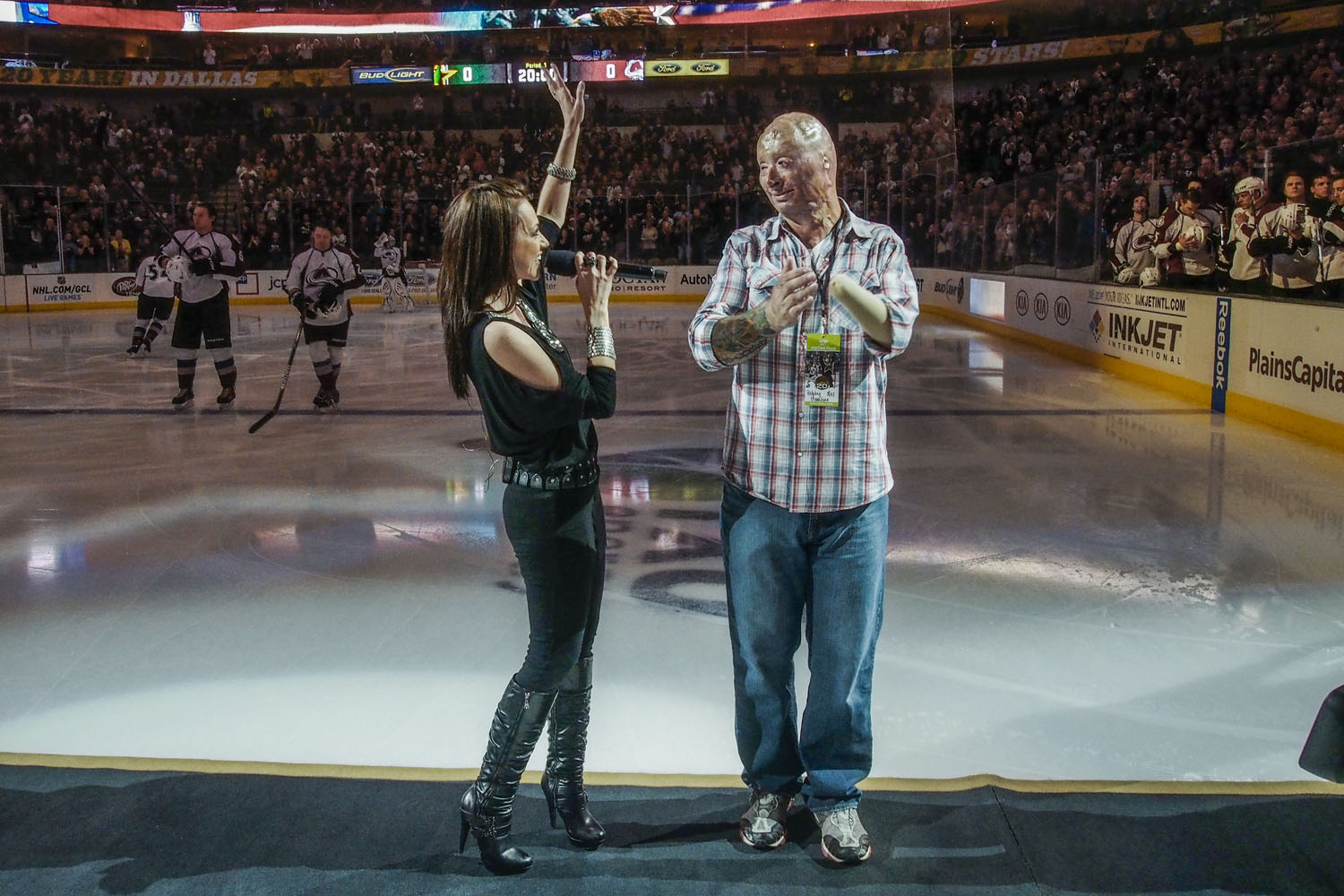 2013.  Dallas, TX.  USA.  Bobby on ice with singer Celine Ray after the national anthem.  He was the center of Military Appreciation night for the Dallas Stars NHL team.  Bobby Henline, 41, veteran of four tours to Iraq and sole survivor of an IED blast that killed the other four soldiers in his humvee in Iraq in 2007.  He is now a standup comedian launching a new career with a routine built around his injuries.  He received burns over 38% of his body in the blast.