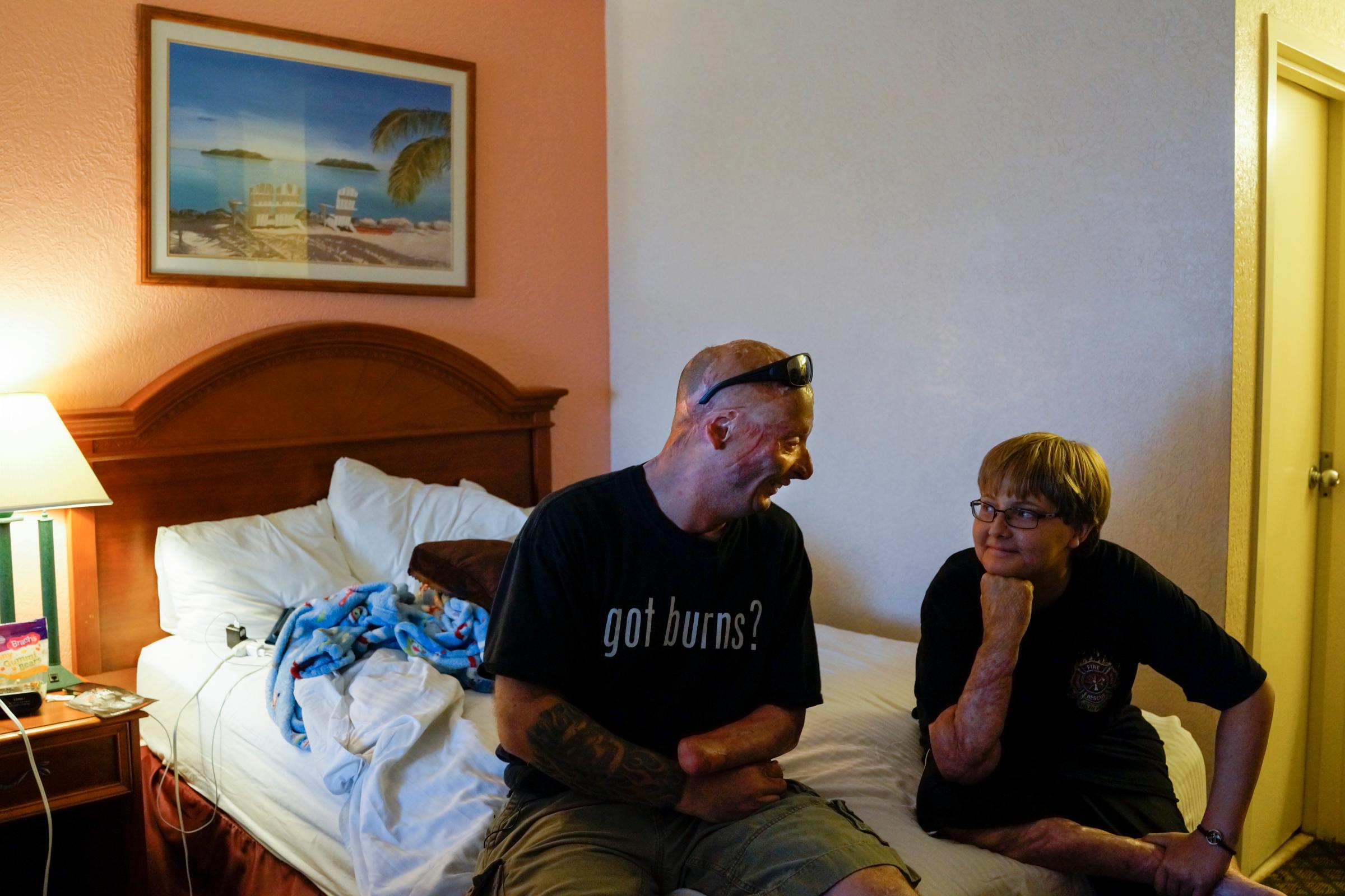2013. Galveston, TX. USA. Bobby tells jokes to Grant, a 12-year old who was burned as a toddler and was about to undergo his 37th surgery. Bobby went to visit him to cheer him up. Bobby says "Most humans will never understand what it's like to be burnt. It's probably the most painful thing to recover from. Surgeries are my biggest fear. I'd go back to Iraq in a second, but tell me i've got another surgery and I'm going to freak out." Bobby Henline, 41, veteran of four tours to Iraq and sole survivor of an IED blast that killed the other four soldiers in his humvee in Iraq in 2007. He is now a standup comedian launching a new career with a routine built around his injuries. He received burns over 38% of his body in the blast.