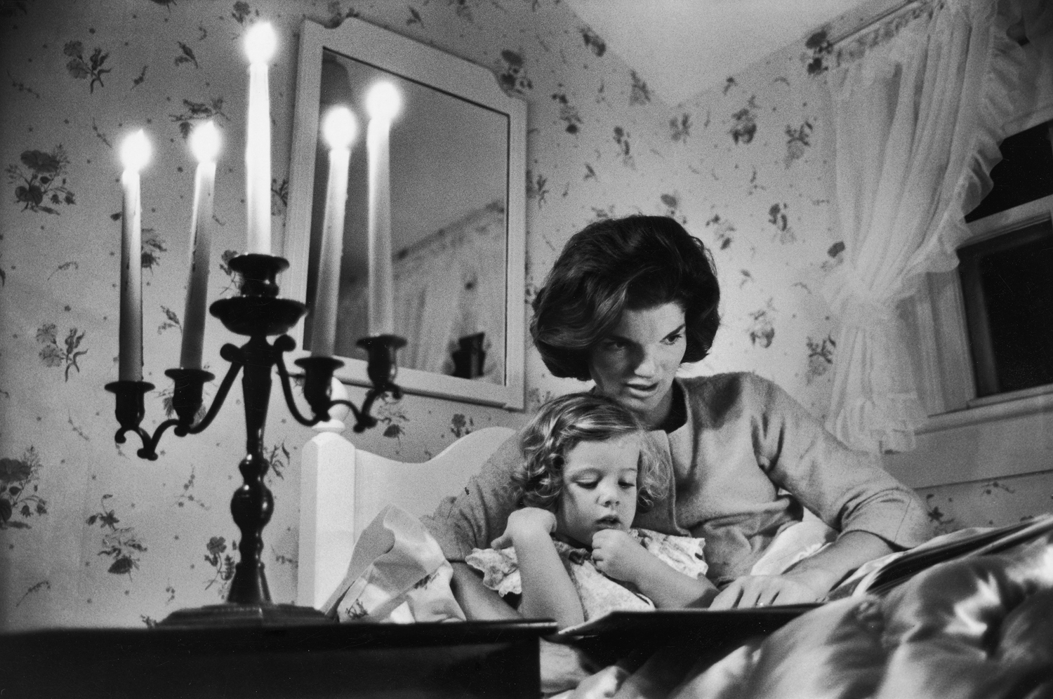 Jackie Kennedy reads to her daughter Caroline at the Kennedy family home in Hyannis Port, Mass., 1960.