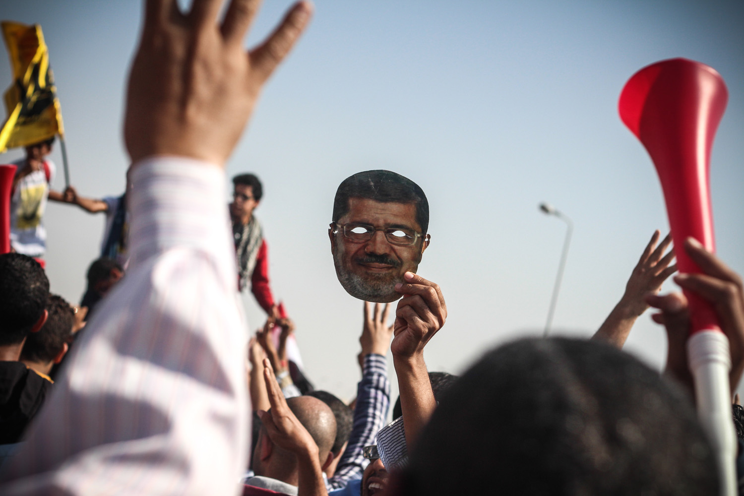 Nov. 4th, 2013. Supporters of Mohamed Morsi brandish a face mask of the ousted president during protests at the Police Academy in Cairo where his trial took place.