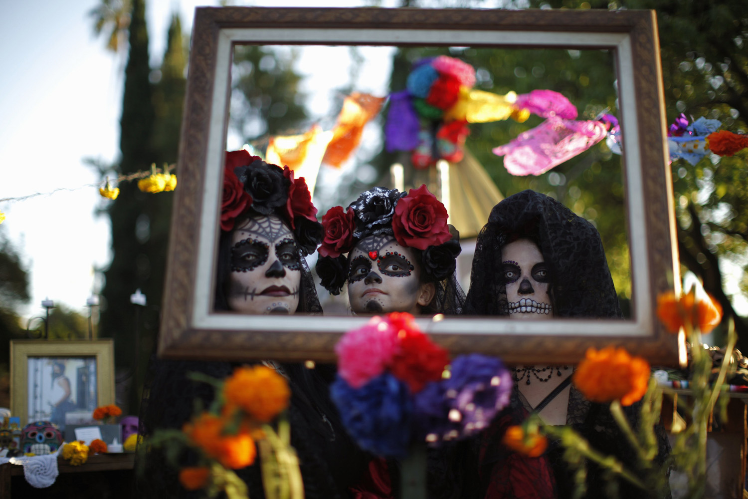 Giron and her daughter Walters pose in a picture frame on an altar during the 14th annual Dia de los Muertos festival at Hollywood Forever Cemetery in Los Angeles