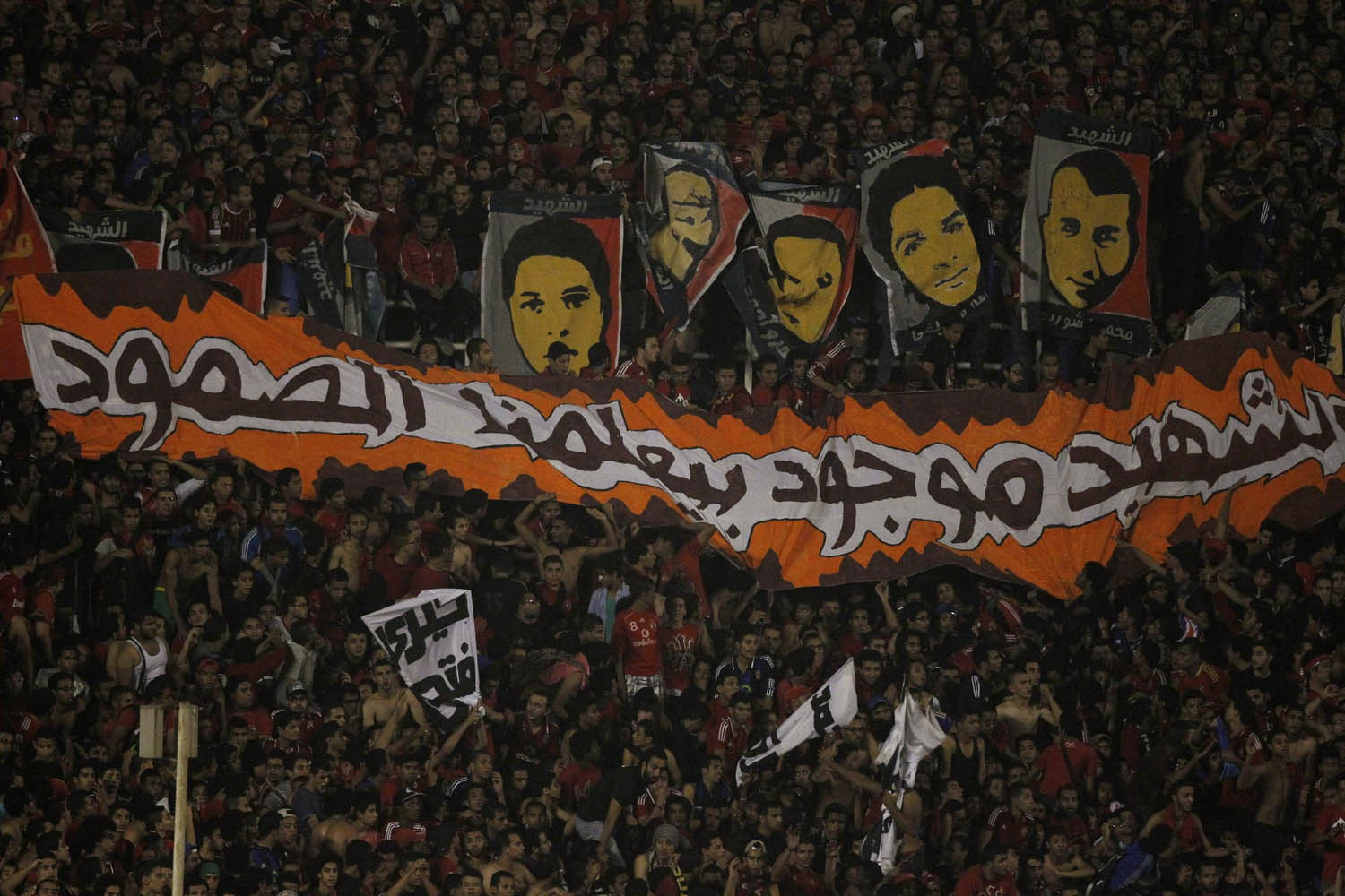 Fans of Egypt's Al-Ahli hold portraits and banner during the team's African Champions League final soccer match in Cairo