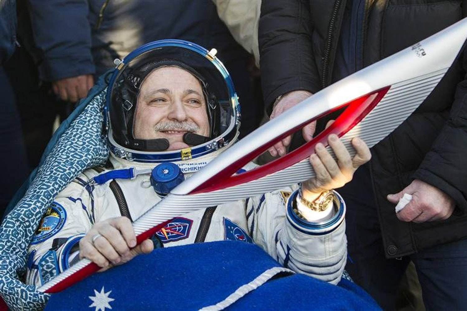 ISS crew member Russian cosmonaut Fyodor Yurchikhin holds the torch of the 2014 Sochi Winter Olympic Games after landing near the town of Zhezkazgan in central Kazakhstan