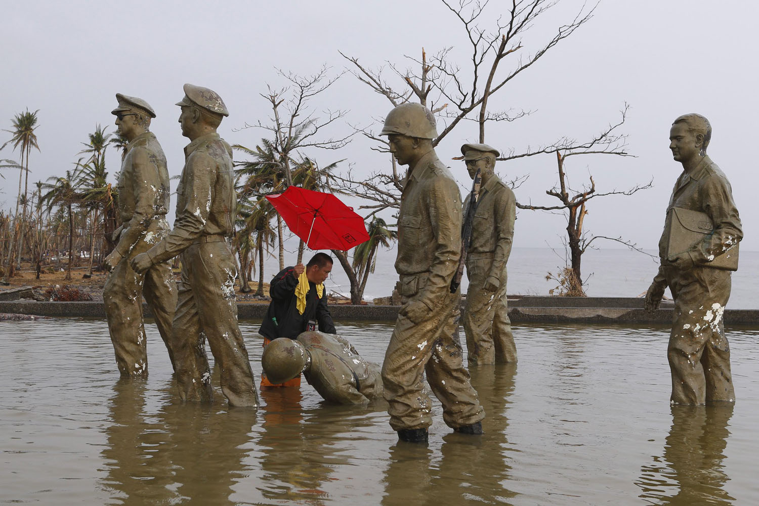 A resident inspects one of the statues at the U.S. General Douglas MacArthur shrine that fell at the height of super typhoon Haiyan last Friday in Palo, Leyte province