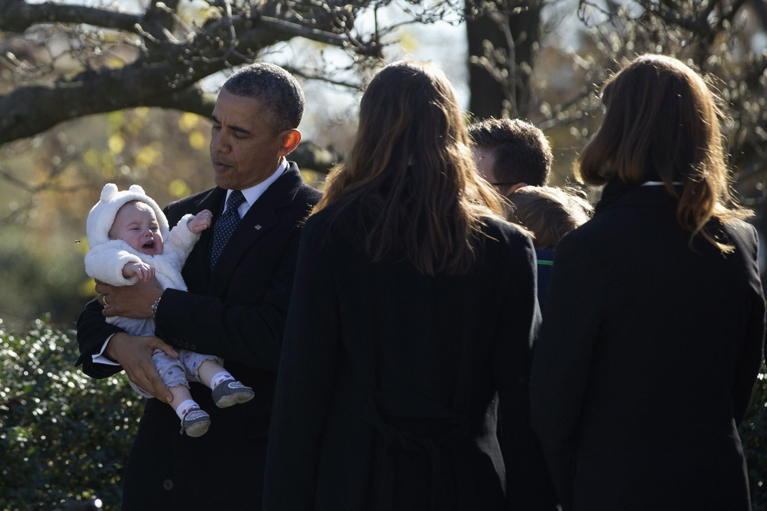 Nov. 20, 2013. U.S. President Barack Obama holds a baby, part of the Kennedy extended family, during a wreath laying in honor of assassinated U.S. President John F. Kennedy at Arlington National Cemetery near Washington.