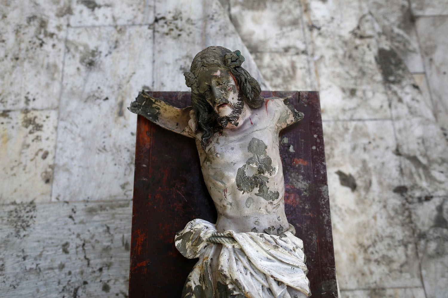 A damaged statue of Jesus Christ that was recovered from rubbles is placed in a church in an area wrecked by Typhoon Haiyan in Tacloban