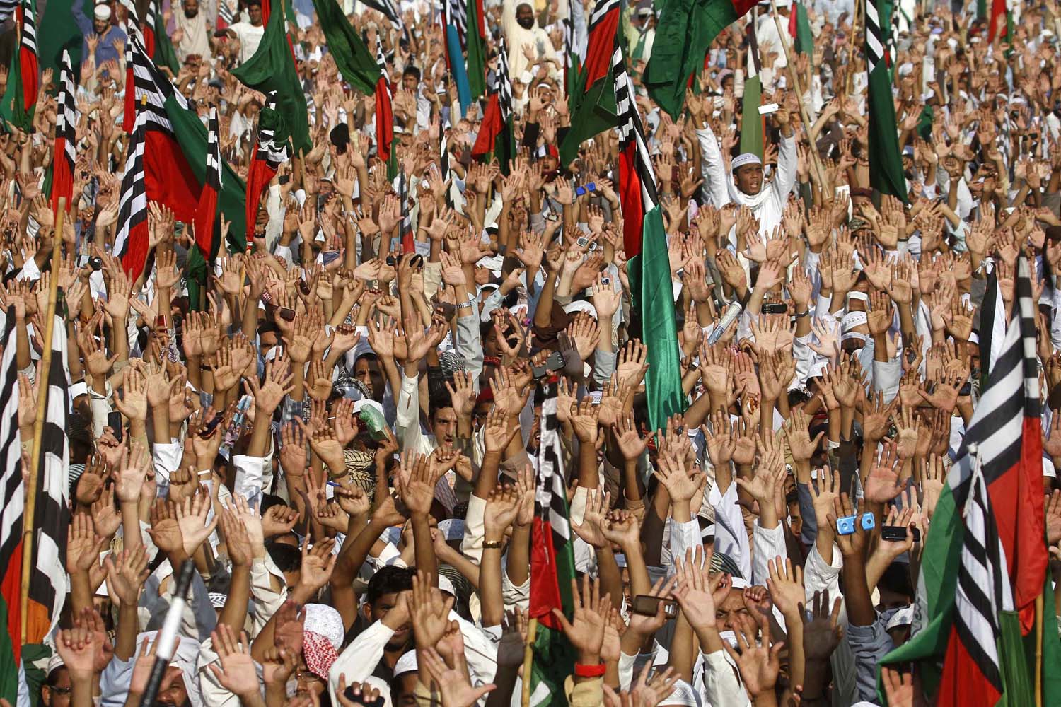 Nov. 22, 2013. Supporters of Ahl-i-Sunnat Wal Jamaat (ASWJ), a political and religious group, raise their hands during a protest in Karachi, Pakistan.