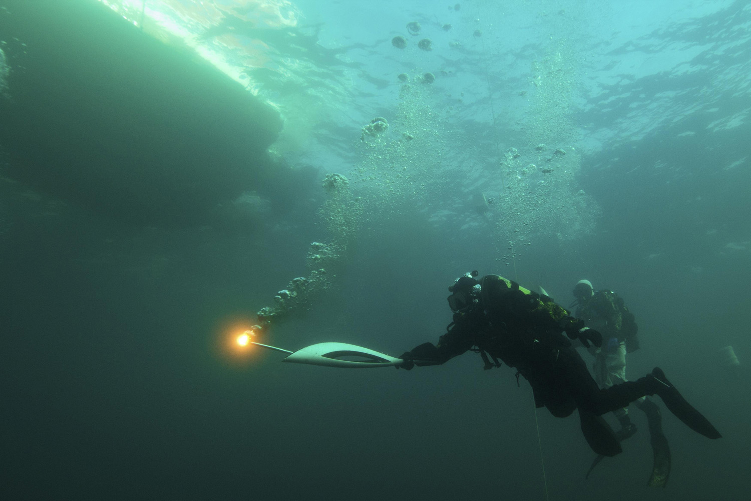 A torchbearer dives with the 2014 Sochi Winter Olympic Games torch in Lake Baikal