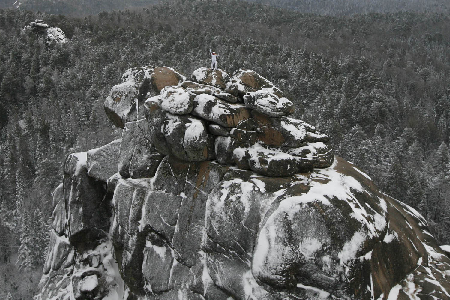 Nov. 26, 2013. Russian alpinist Vladimir Gunko stands at the top of the rock named  The First Stolb  (the First Pillar) at the Stolby national nature reserve during the Sochi 2014 Winter Olympic torch relay in the Siberian Taiga area outside Krasnoyarsk.