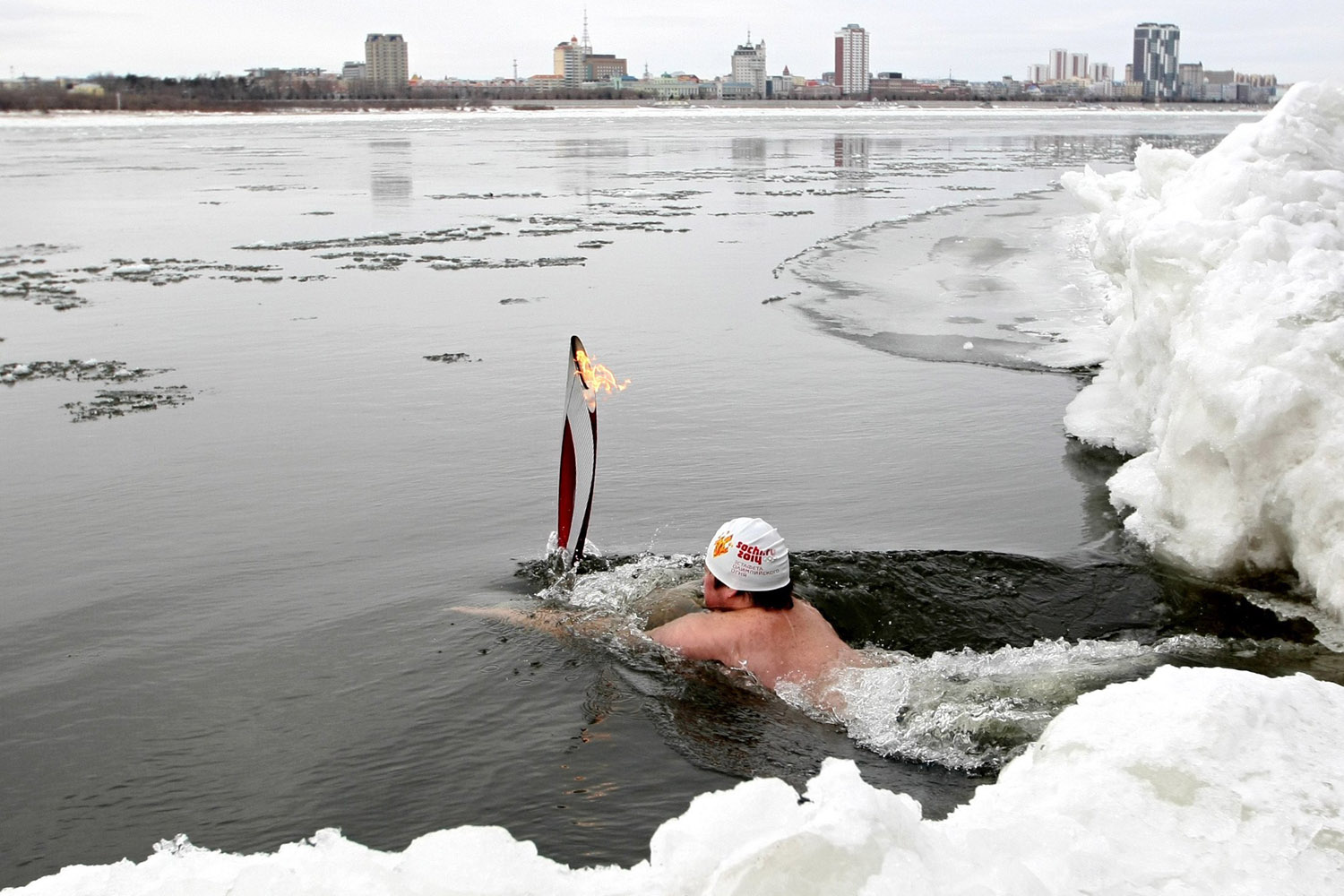 Nov. 19, 2013. Athletes swim with the Olympic flame in the Amur River on Day 44 of the Sochi 2014 Olympic Torch Relay in Blagoveshchensk, Russia.