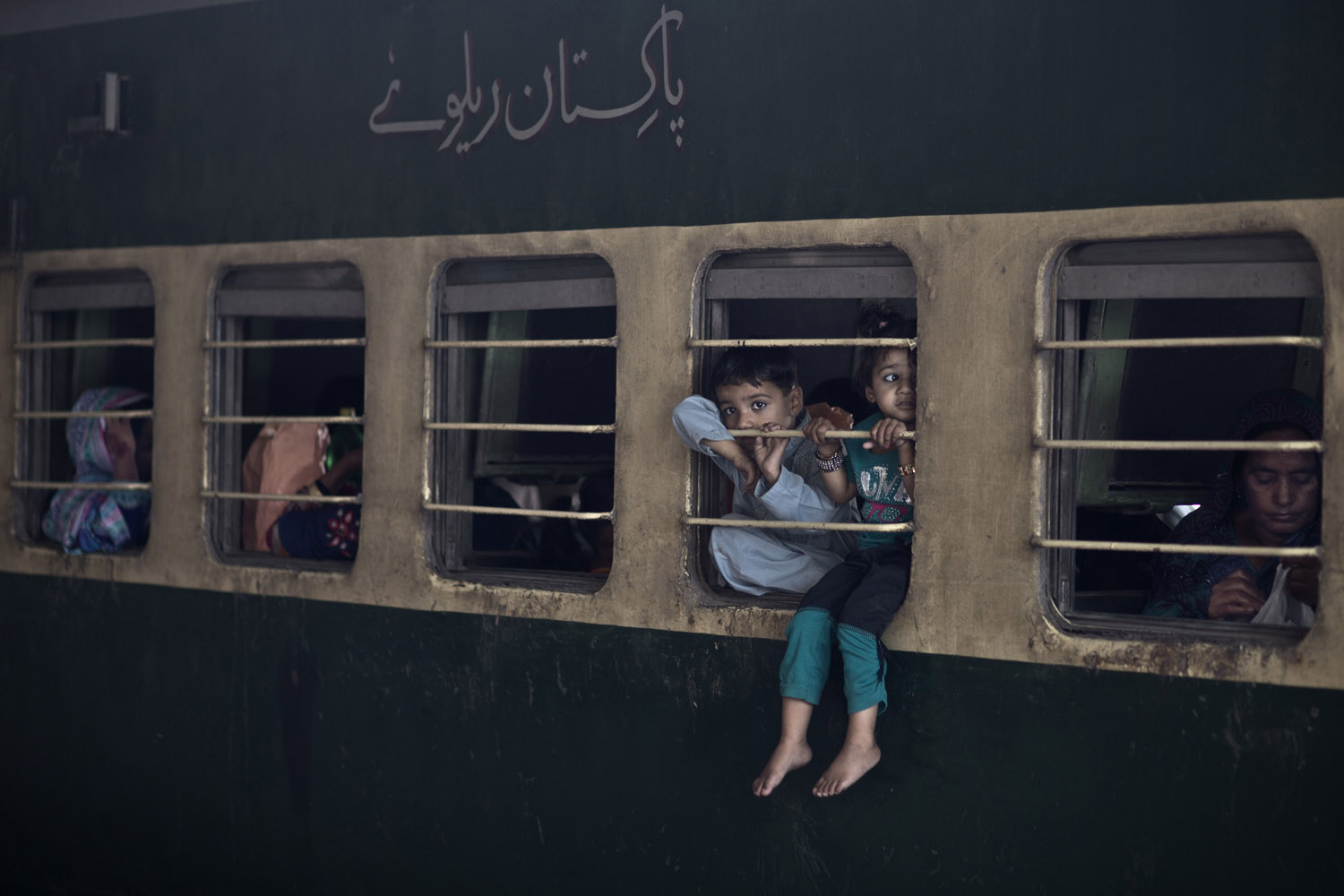 Sept. 20, 2013. While waiting to travel with their family from Rawalpindi to Peshawar, Pakistani children sit on the window of a train, to escape the heat trapped inside the cabin, as temperatures reached 91.4 degrees Fahrenheit (33 degrees Celsius), at Rawalpindi railway station. The Urdu on the train reads,  Pakistan Railway.
