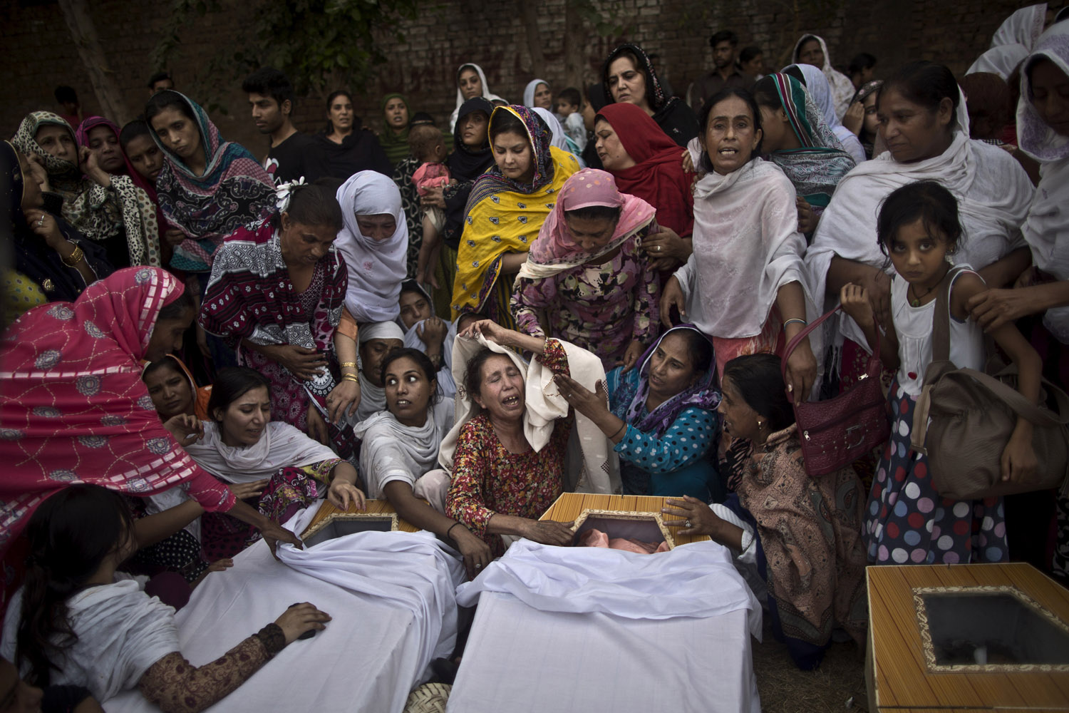 Sept. 22, 2013. Pakistani women grieve over the coffins of their relatives, who were killed in a suicide attack on a church in Peshawar.