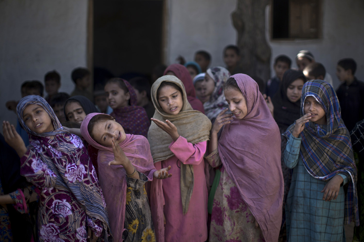 Oct. 14, 2013. Pakistani schoolgirls, who were displaced with their families from Pakistan's tribal areas due to fighting between the Taliban and the army, sing with their teacher before starting their classes, at their makeshift school on the outskirts of Islamabad.