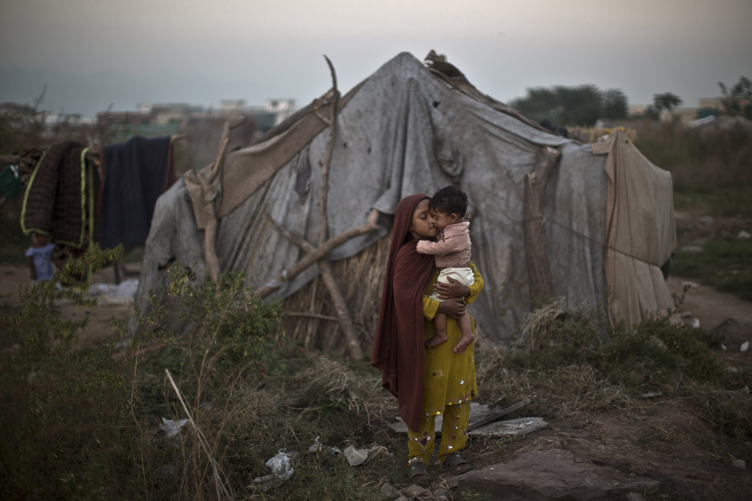 Oct. 21, 2013. A Pakistani girl comforts her brother near her family's makeshift tent in a slum in Islamabad.