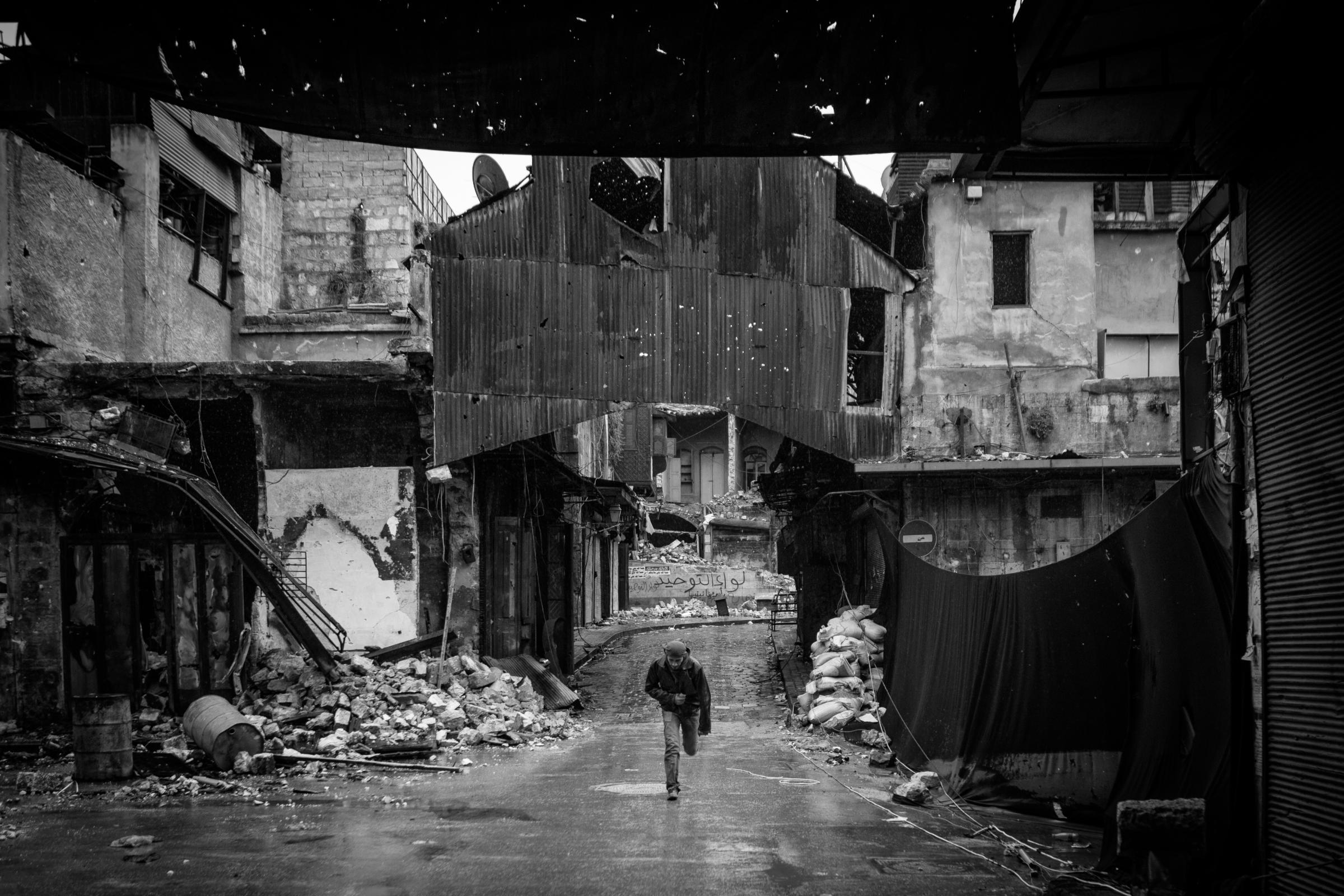 A Free Syrian Army soldier runs while being shot at by Assad's snipers in Aleppo, Syria, on Jan. 7, 2013.