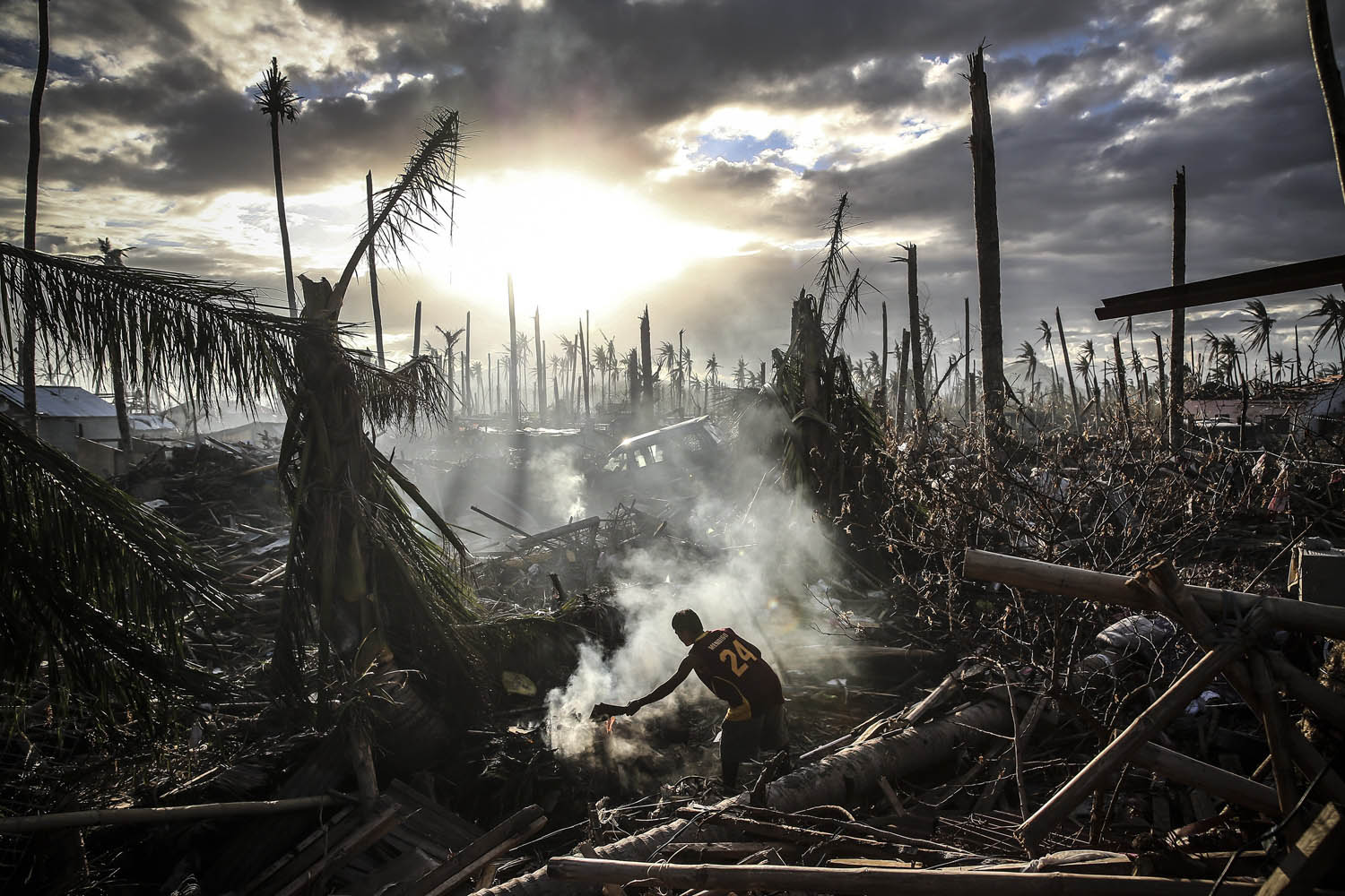 Nov. 19, 2013. A man fans the flames of a fire in Leyte, Philippines.