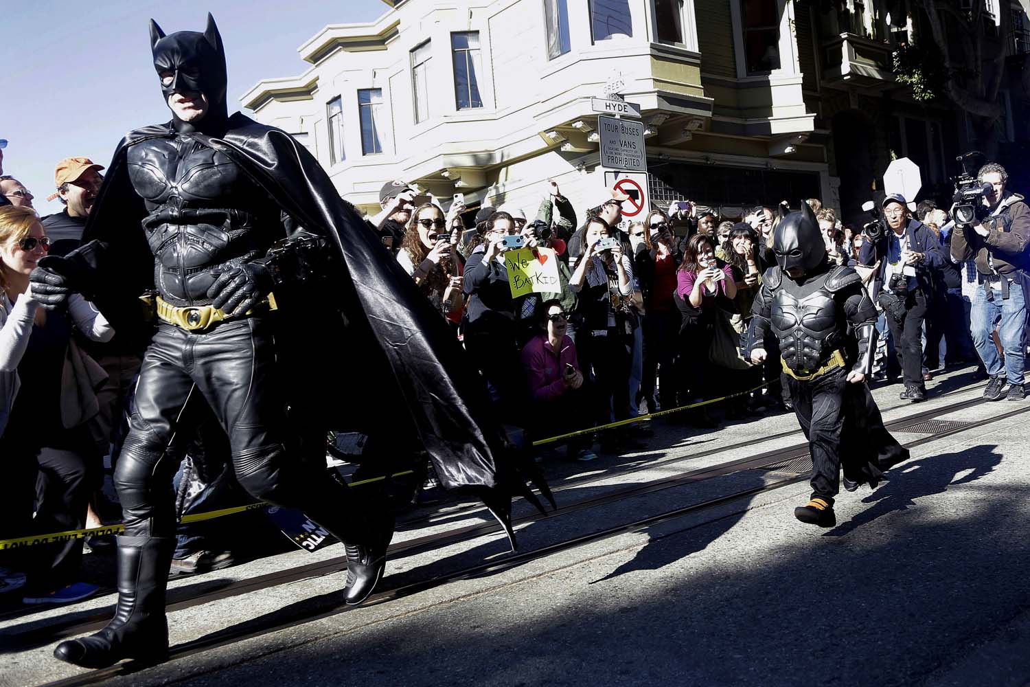 Nov. 15, 2013. Miles Scott, dressed as Batkid, right, runs with Batman after saving a damsel in distress in San Francisco.