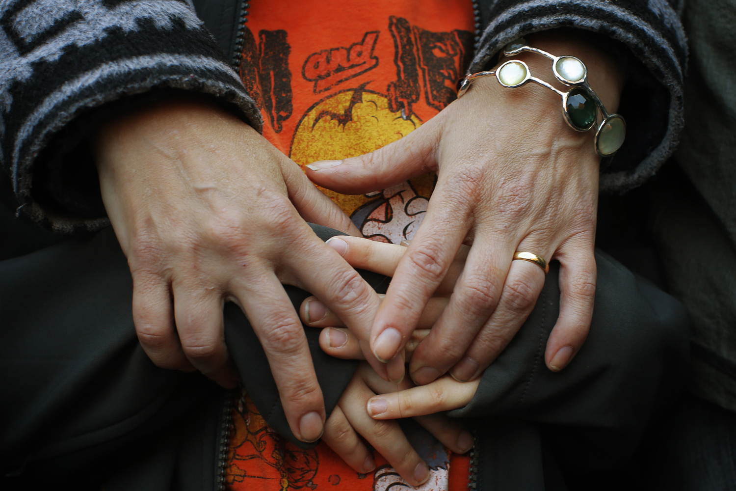 A mother holds the hands of her son as they attend an interfaith worship service at a memorial on Boylston Street for the victims of the Boston Marathon bombings in Boston