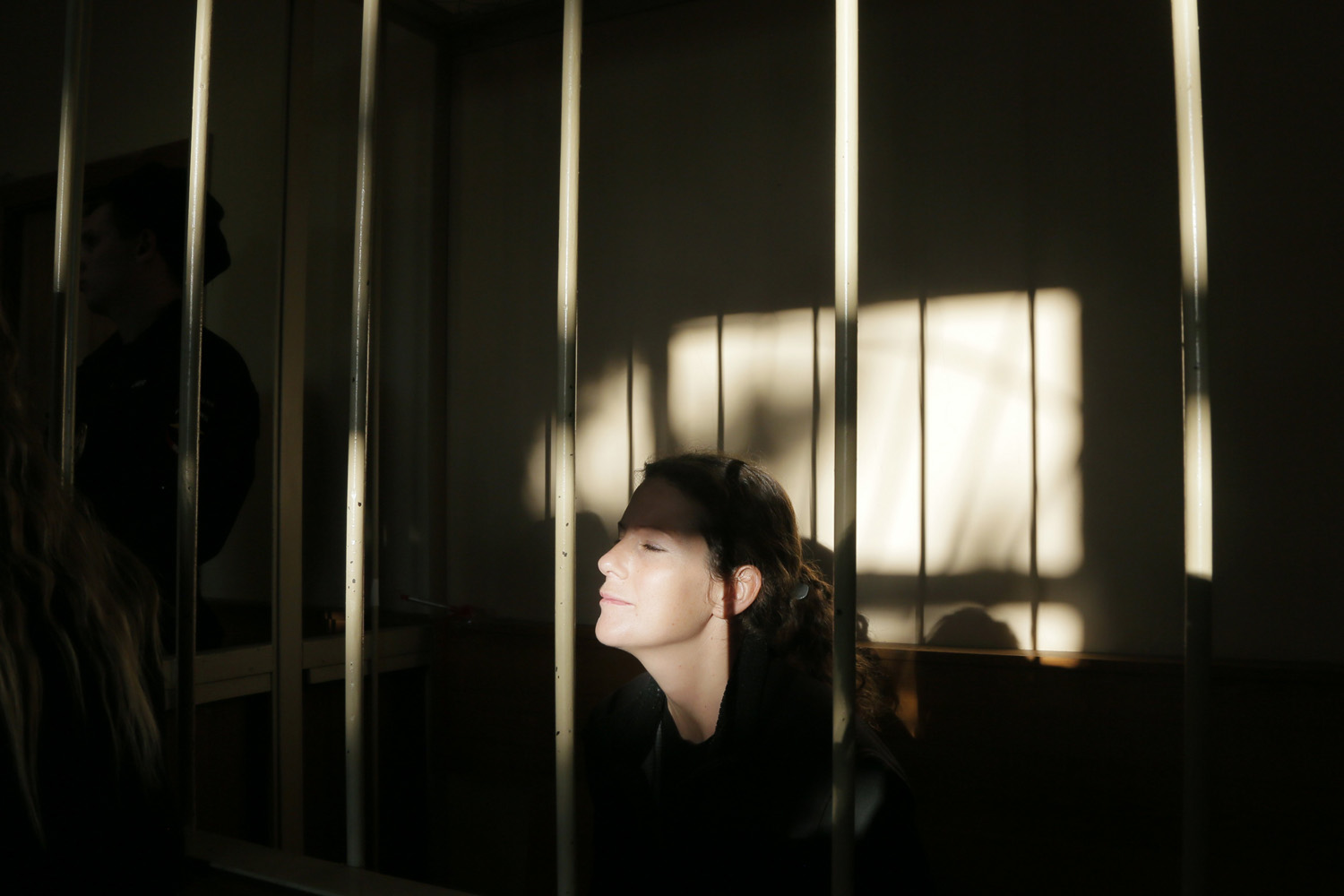 Nov. 18, 2013. Greenpeace International activist Ana Paula Alminhana Maciel of Brazil sits behind bars during a court hearing to consider the request to extend the detention of 30 members of the Arctic Sunrise Greenpeace International ship in St. Petersburg, Russia.