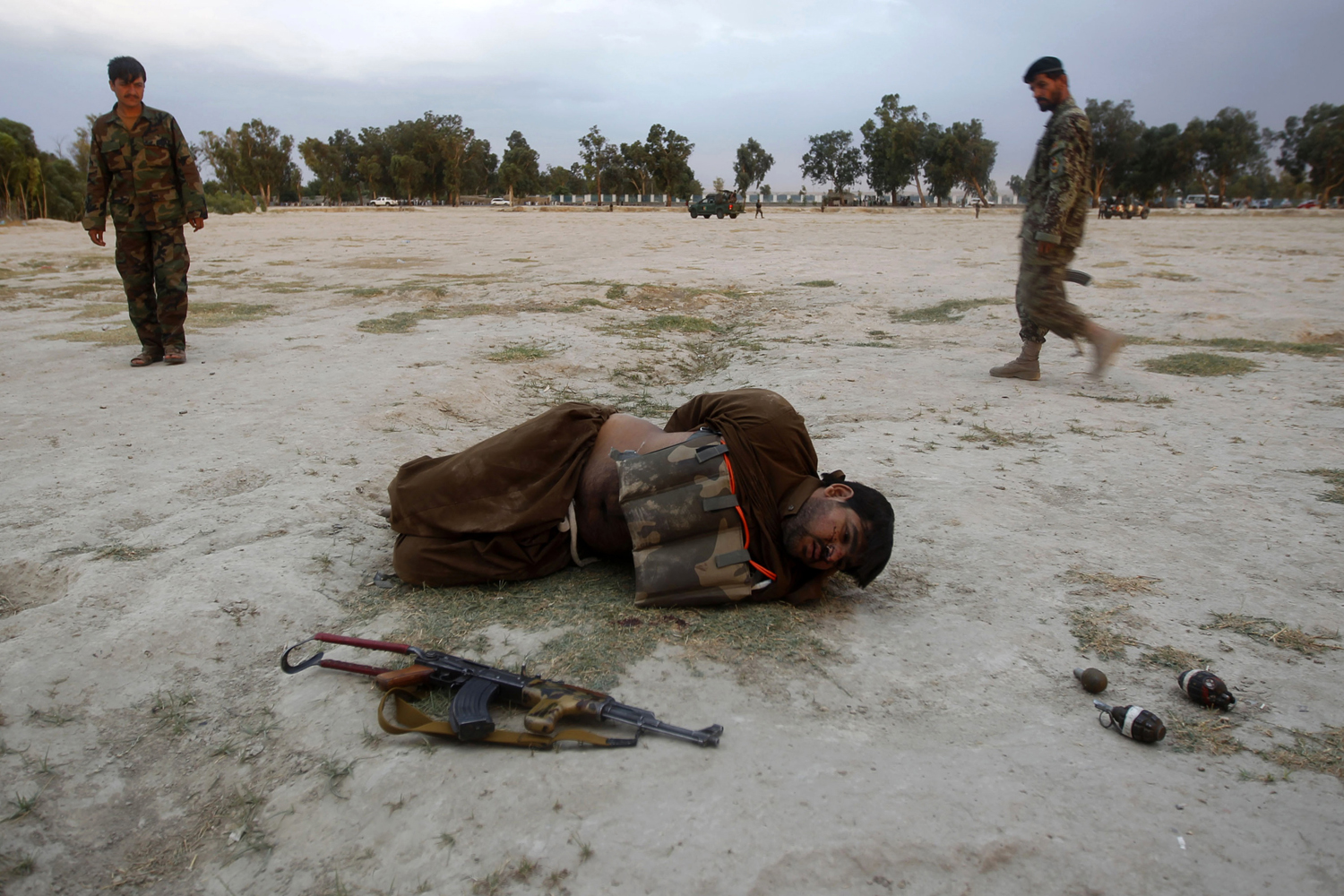 Afghan National Army (ANA) soldiers approach a suicide attacker after his vest was defused in Jalalabad province