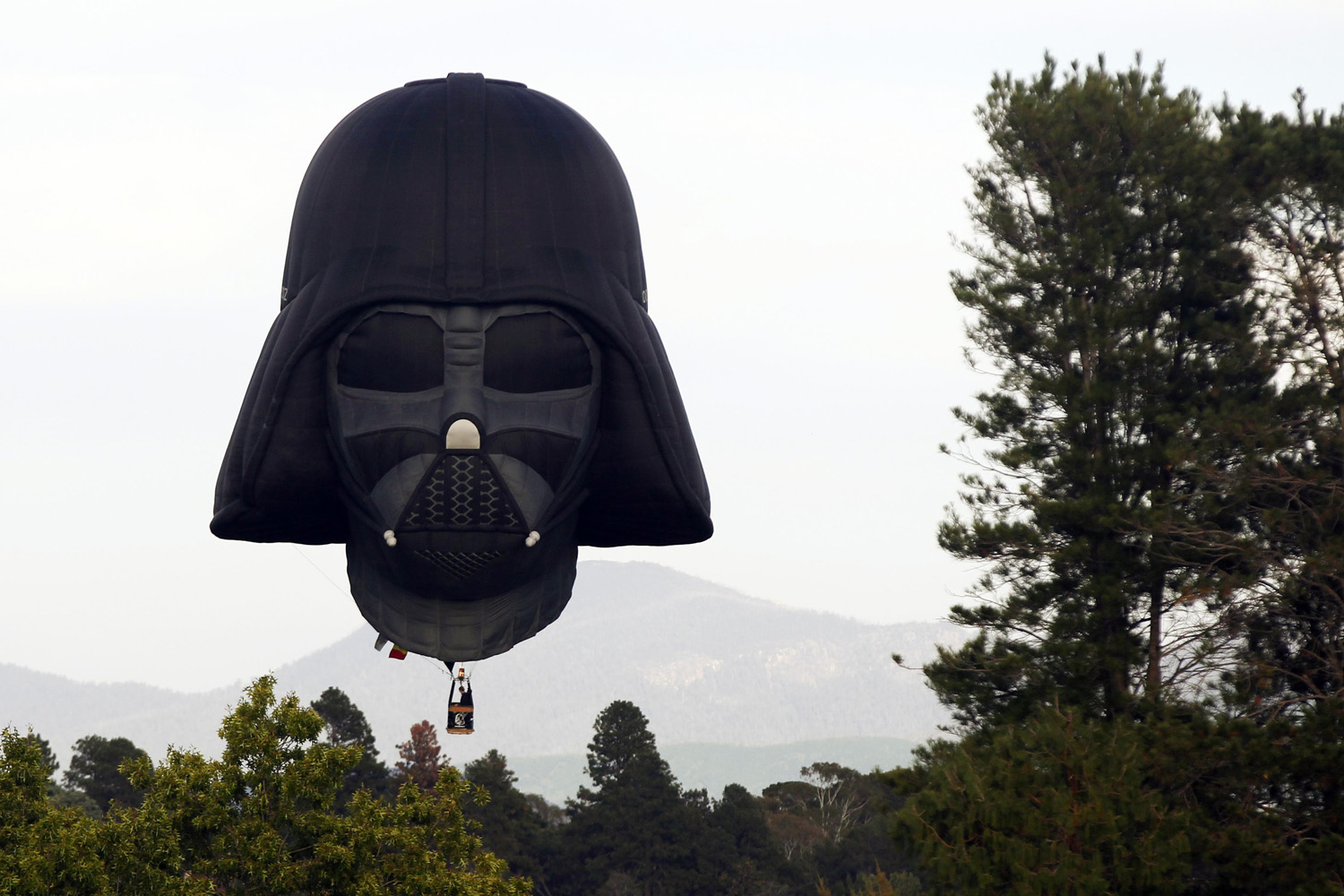 Hot air balloon shaped like Darth Vader's head lands after a sunrise flight in Canberra