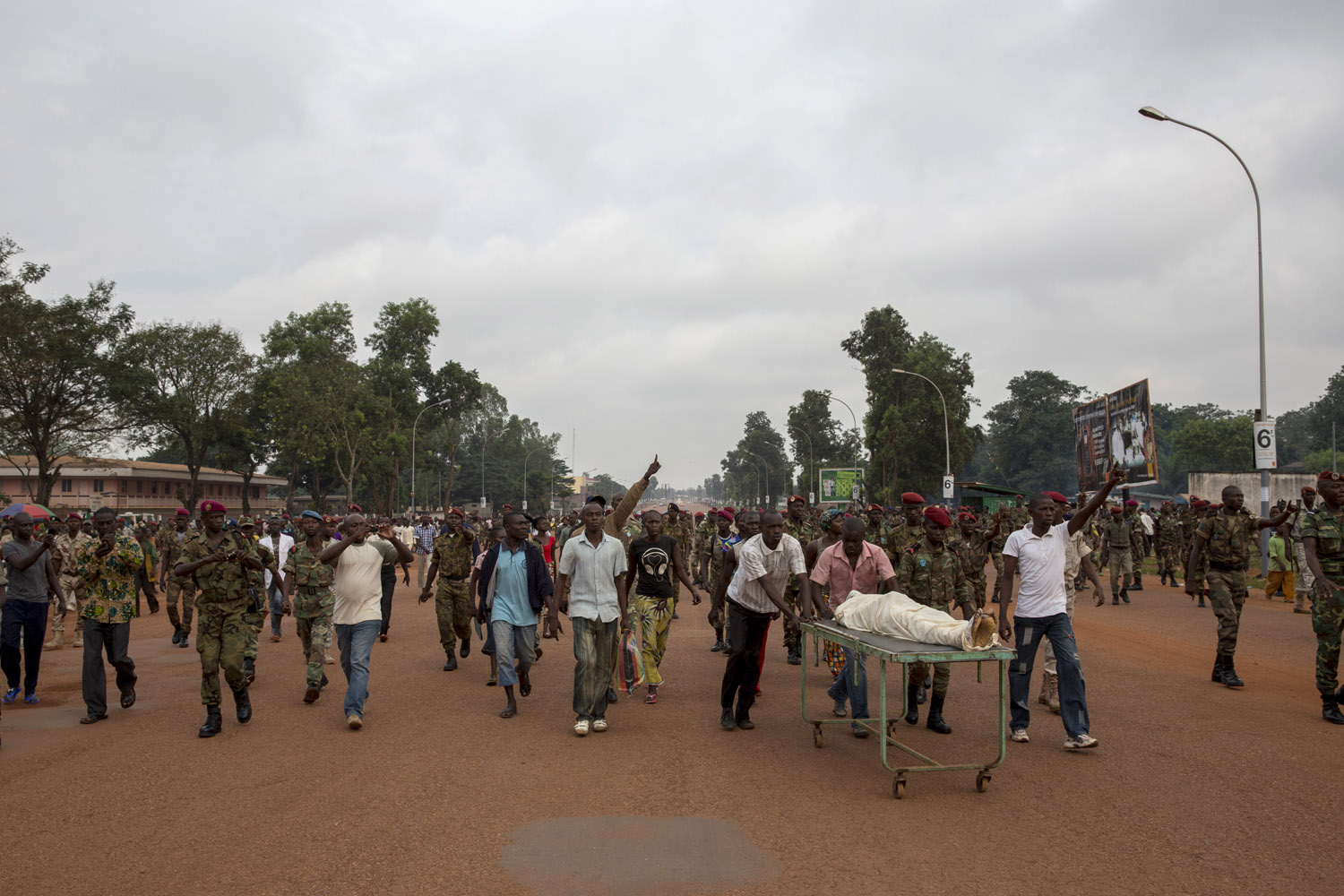 Army soldiers and family members walk on the main road in Central Bangui with the body of a man who was shot dead by Seleka members. They then demonstrated shooting "enough is enough". Murders became frequent since the last 2 weeks in Bangui.