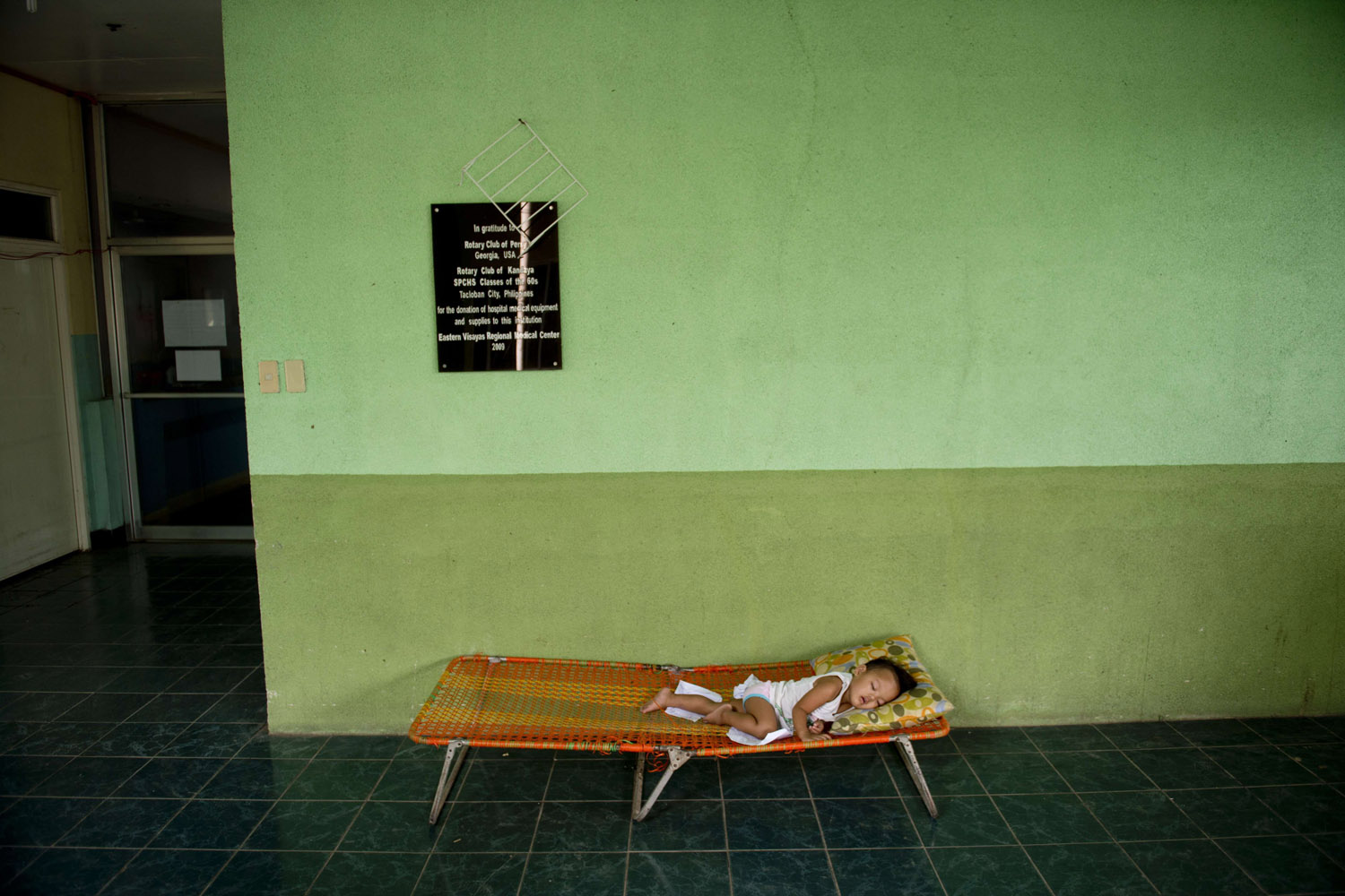 Nov. 20, 2013. A child sleeps on a camping bed outside the overcrowded children's and maternity ward at the Eastern Visayas Medical Center in Tacloban, Philippines.