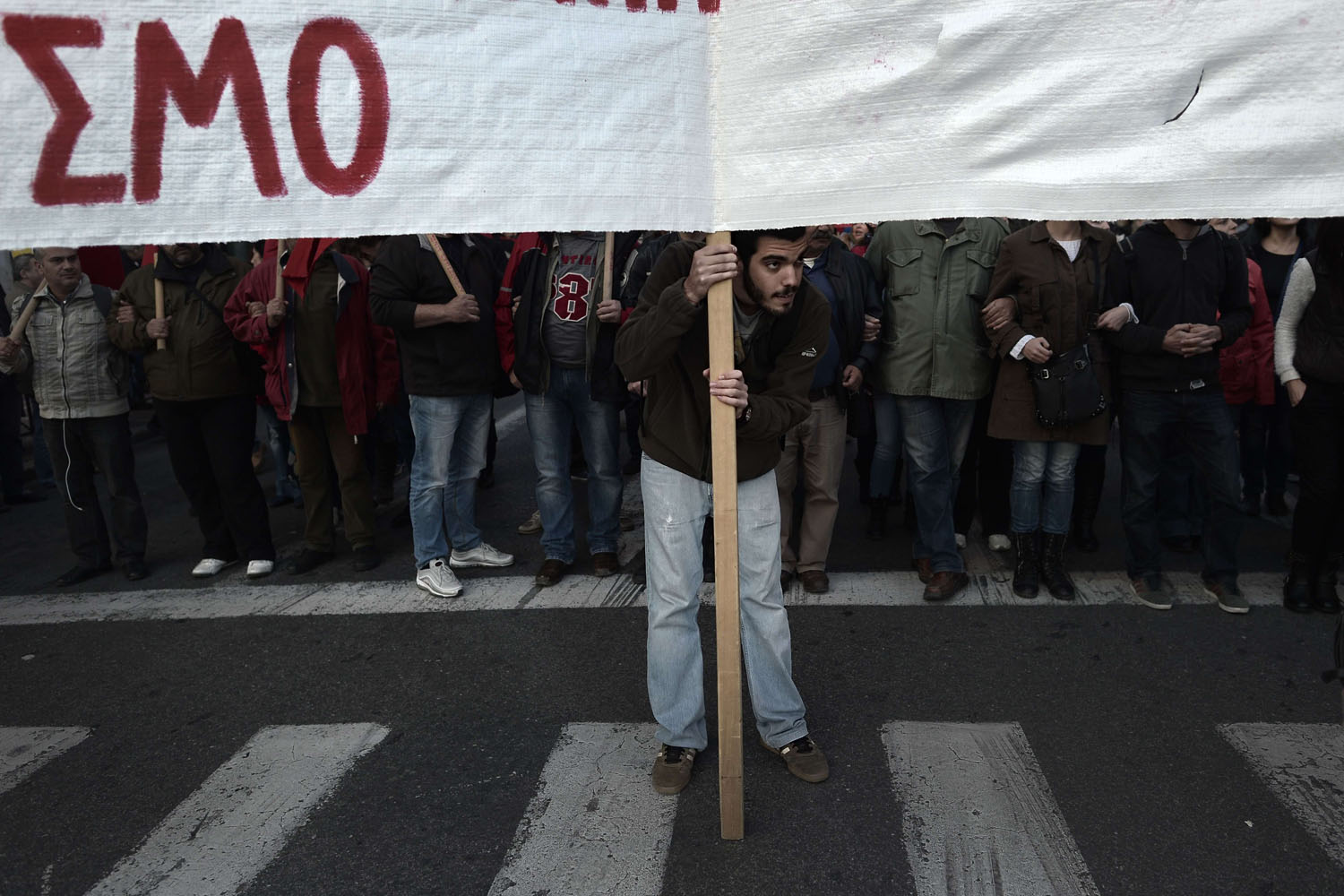 Nov. 17, 2013.
                              A protester holds a banner  in the center of Athens during a march commemorating the 1973 students uprising against the military junta, in Greece.