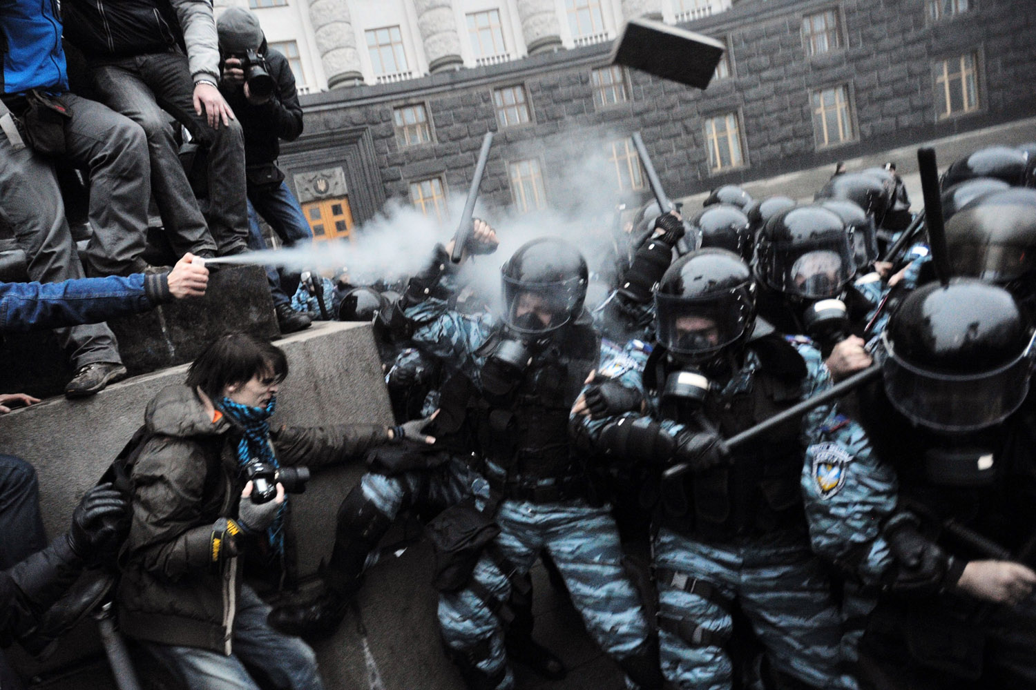 Nov. 24, 2013. Protesters use tear gas and throw stones during clashes with riot police in front of the Cabinet of Ministers of Ukraine during a rally in Kiev.
