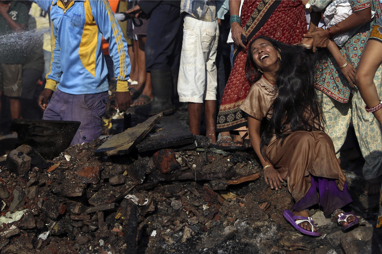 Nov. 21, 2013. An Indian woman cries while her baby is missing after a fire in Ambedkar Nagar slum in Mumbai, India,  No casualties have been reported.