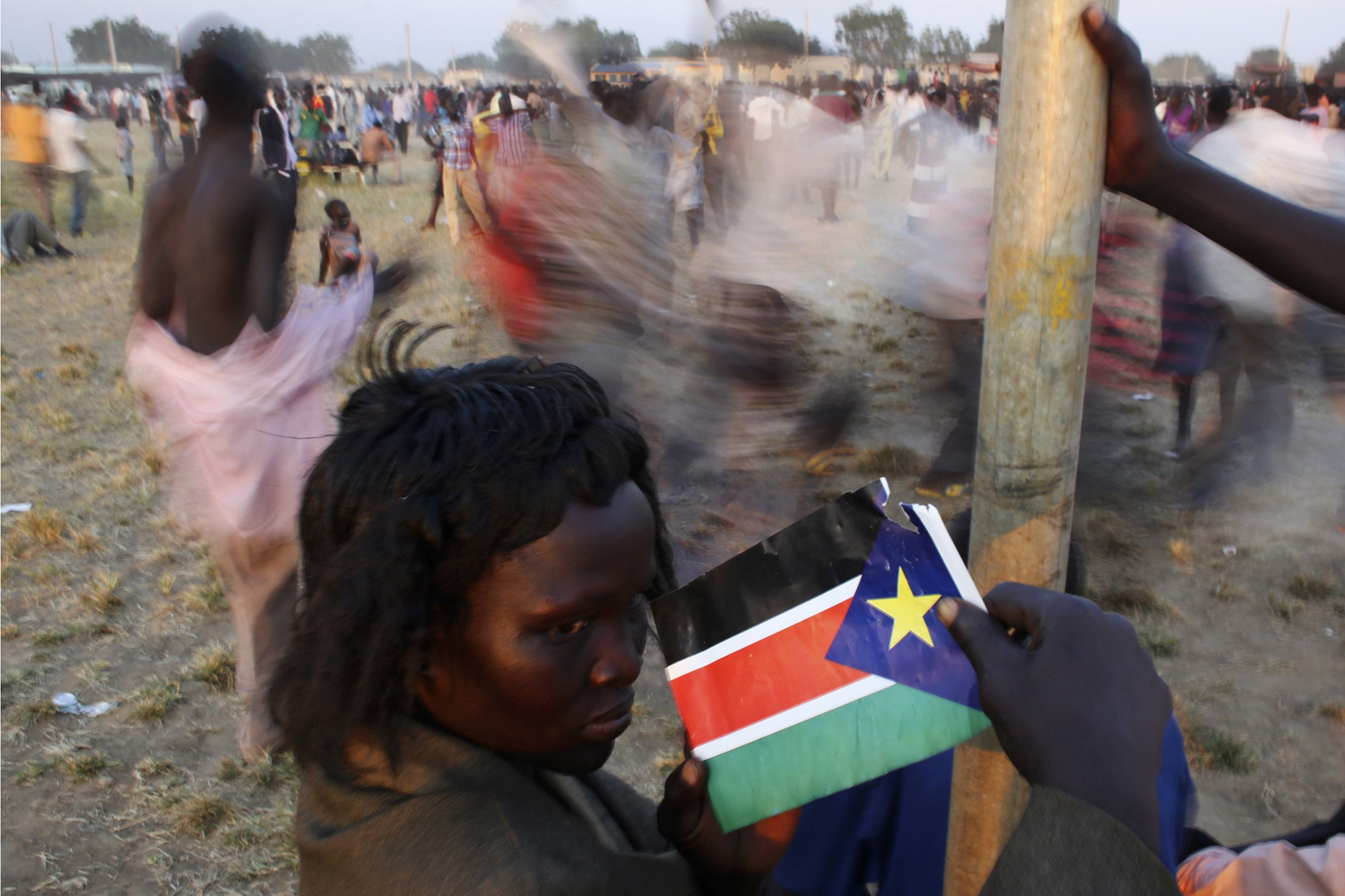 A woman holds South Sudan's national flag during referendum results celebrations in Abyei
