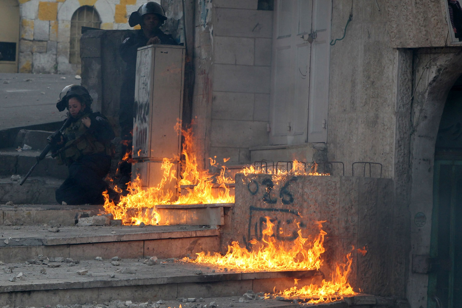 Nov. 27, 2013. A female Israeli border guard reacts after a petrol bomb thrown by Palestinian demonstrators, landed next to her during a demonstration in  the West Bank city of Hebron.