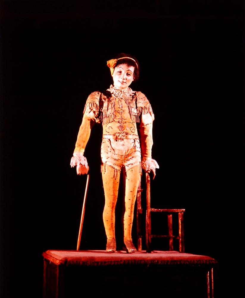 Nineteenth-century French-made mechanical doll raises its feet and lifts its cane until it is supporting itself on one hand.