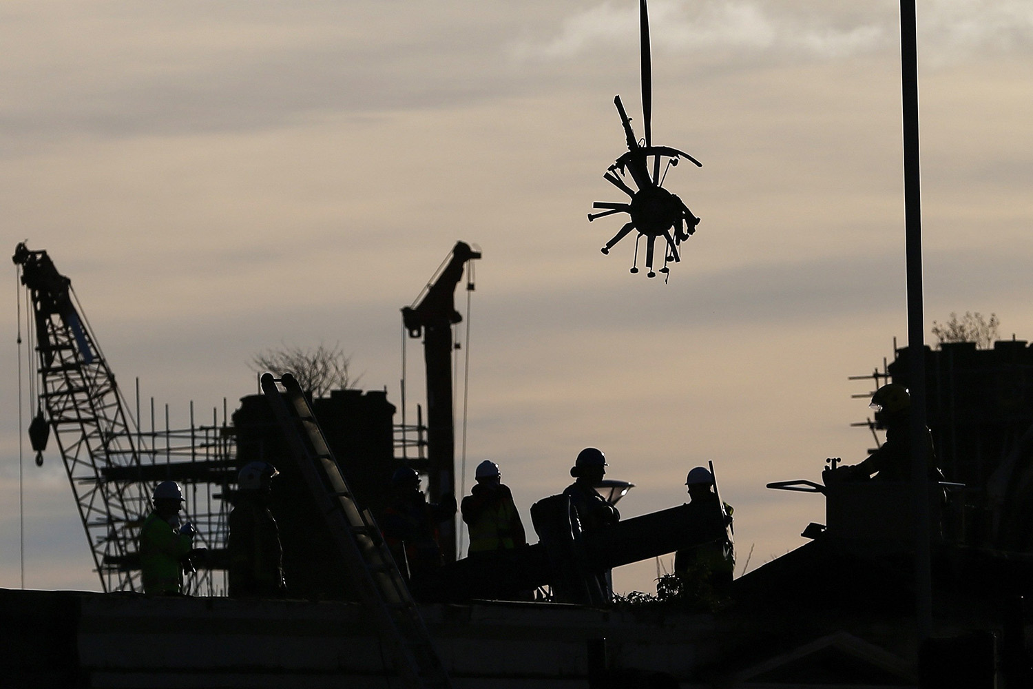 Rescue workers lift the rear rotor blades from the site of a police helicopter crash onto the Clutha Pub in central Glasgow