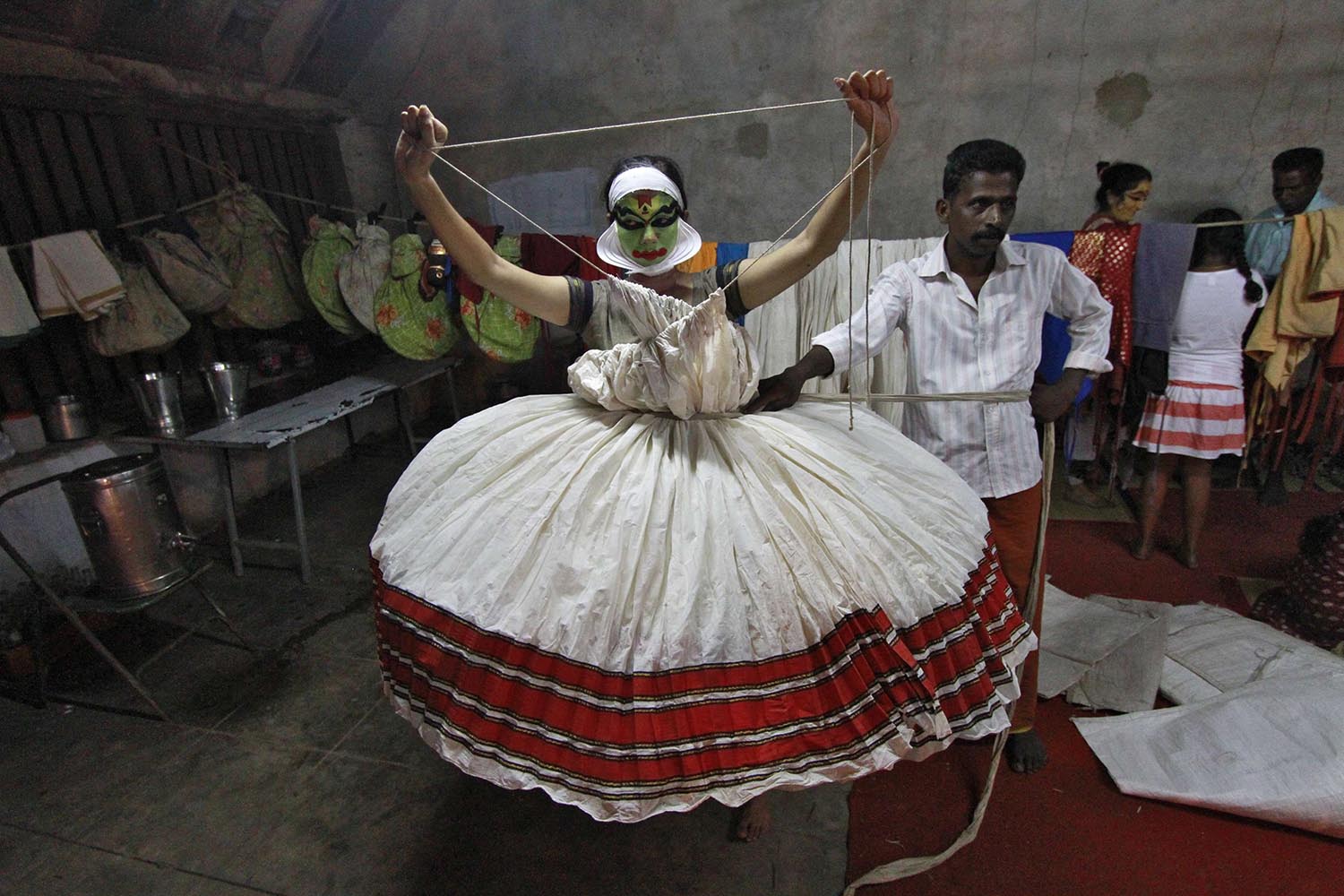 A Kathakali dancer wears a dress ahead of her performance during the annual Vrischikotsavam festival at a temple in Kochi