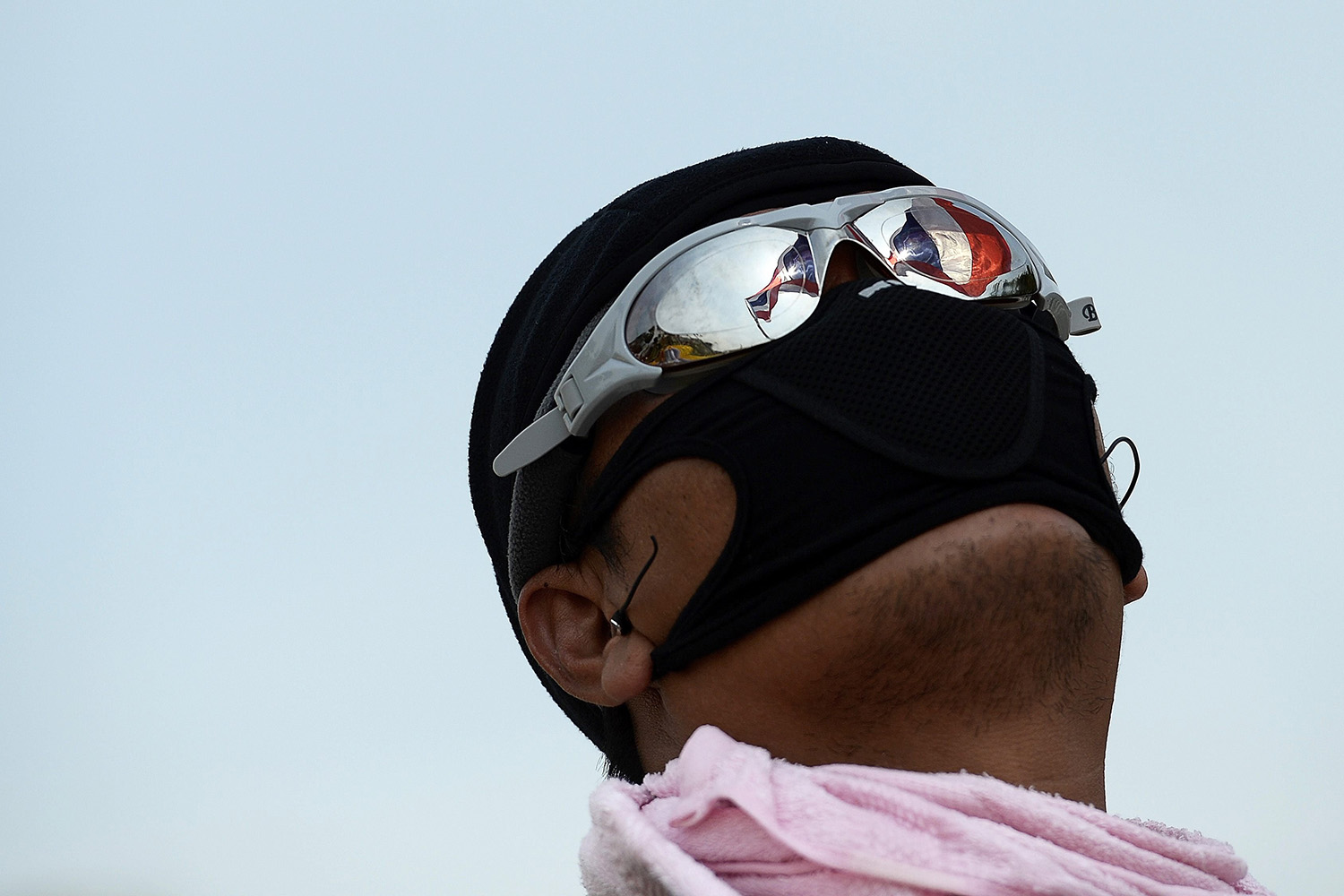 A Thai flag is reflected in an anti-government protester's sunglasses as he celebrates after demonstrations are called off outside Government House in Bangkok
