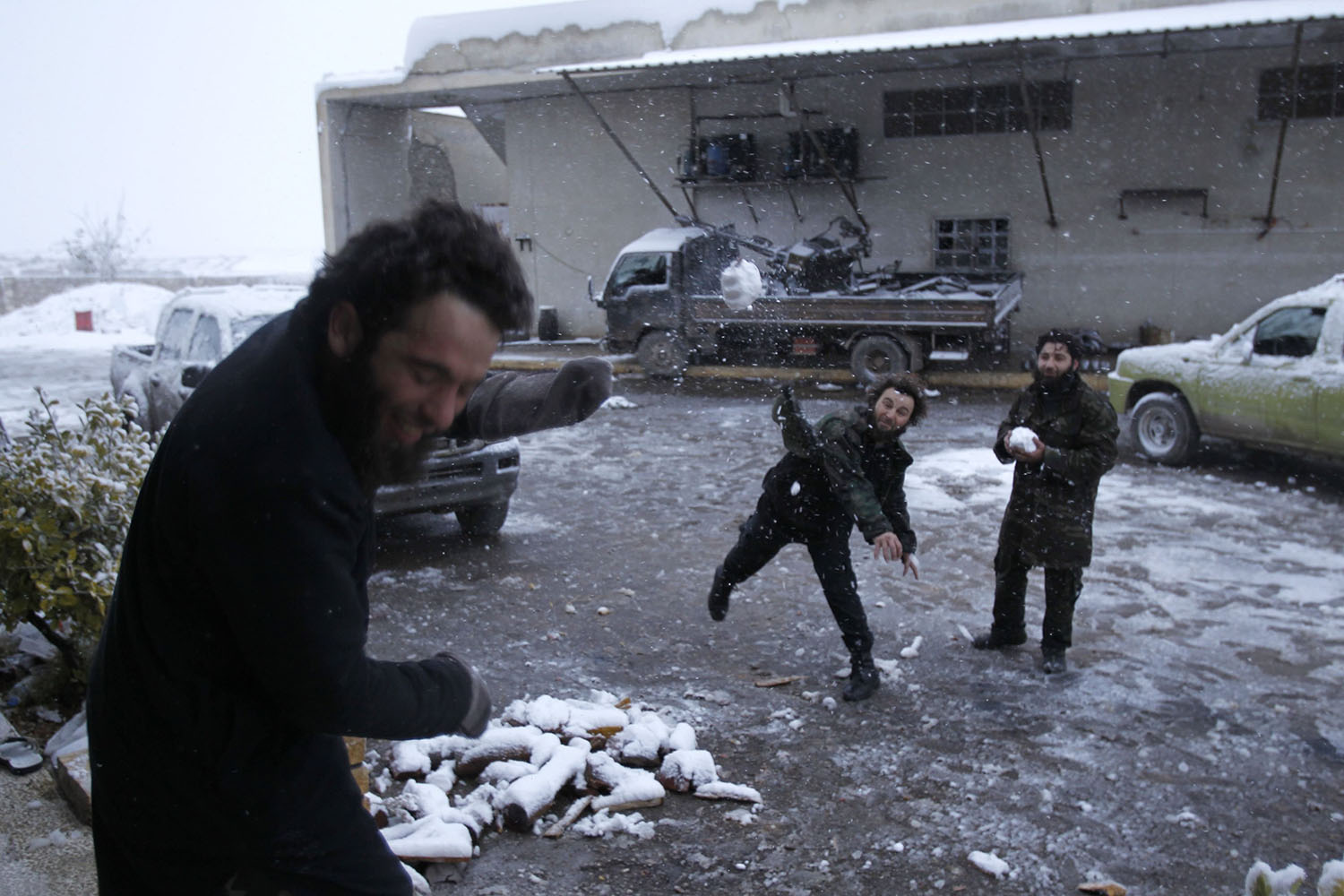 A Free Syrian Army fighter throws snow at his fellow fighter in Khan Tuman, Aleppo