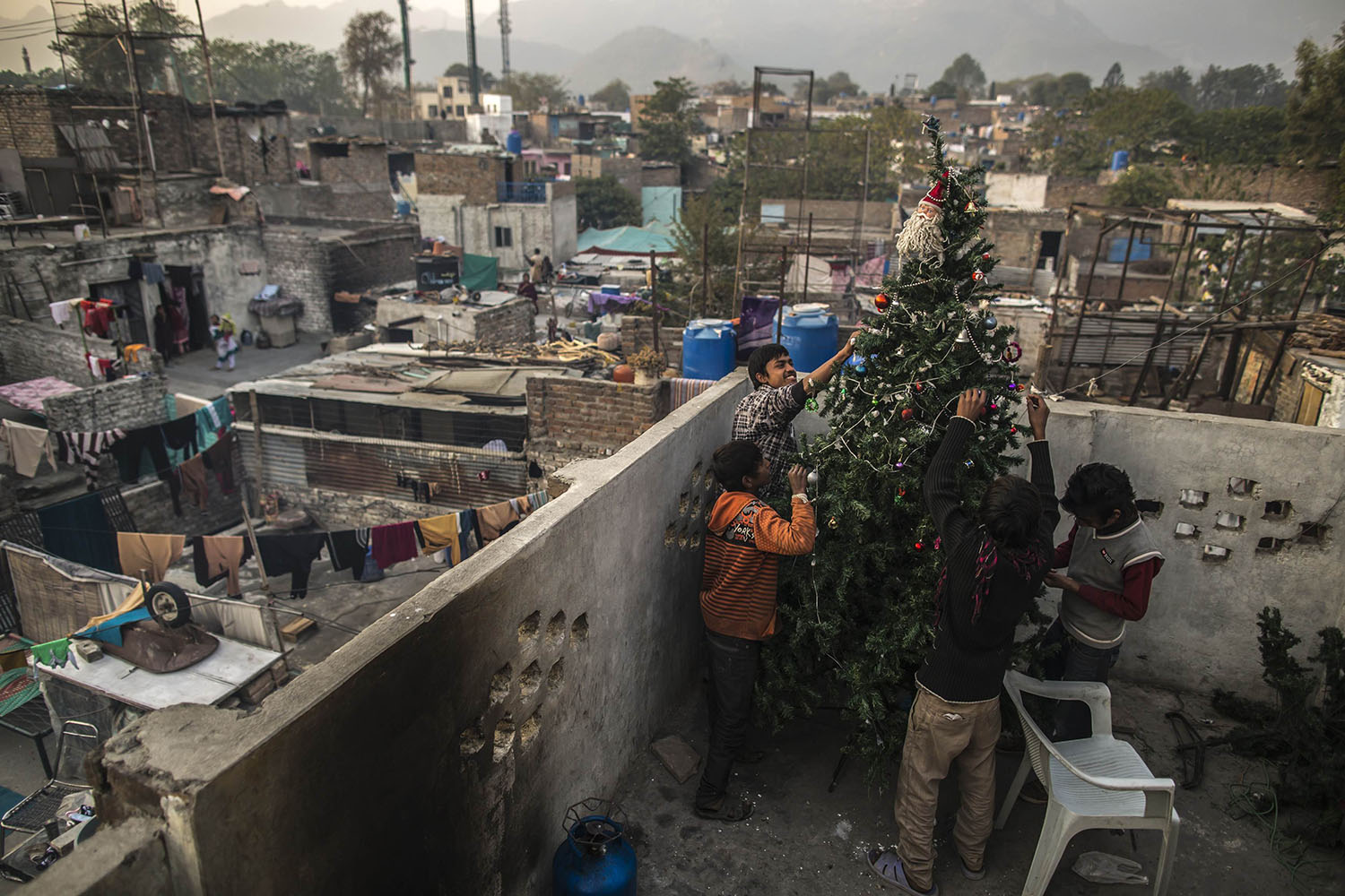 Pakistani Christian boys decorate a Christmas tree on the roof of their house in Islamabad