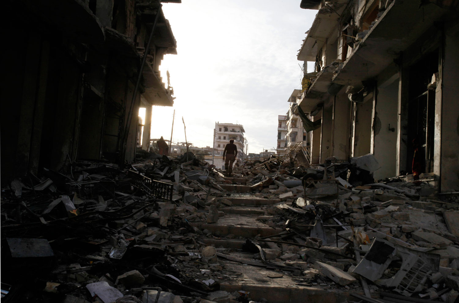 A Free Syrian Army fighter walks up a set of stairs among damage and debris in Aleppo, on Dec. 1, 2013.