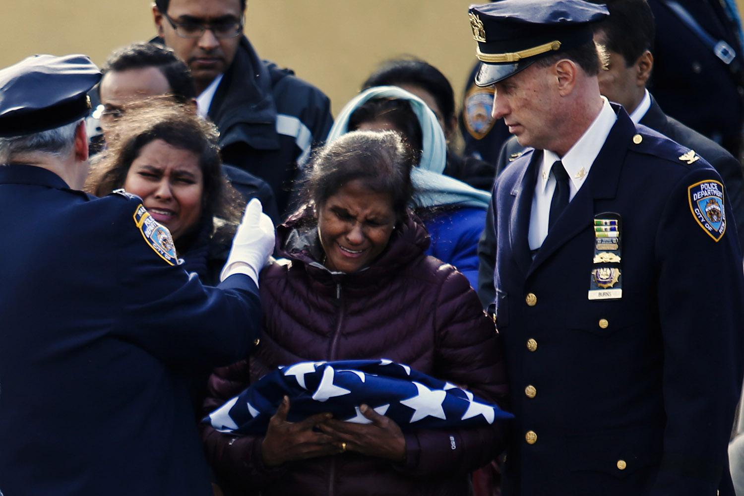 Dammika cries after receiving the flag that covered the casket of her husband during his wake service in New York
